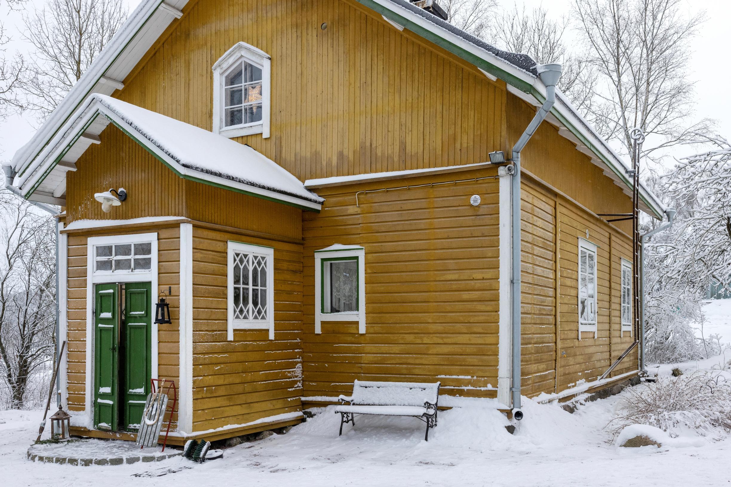 Yellow wooden house with a green door