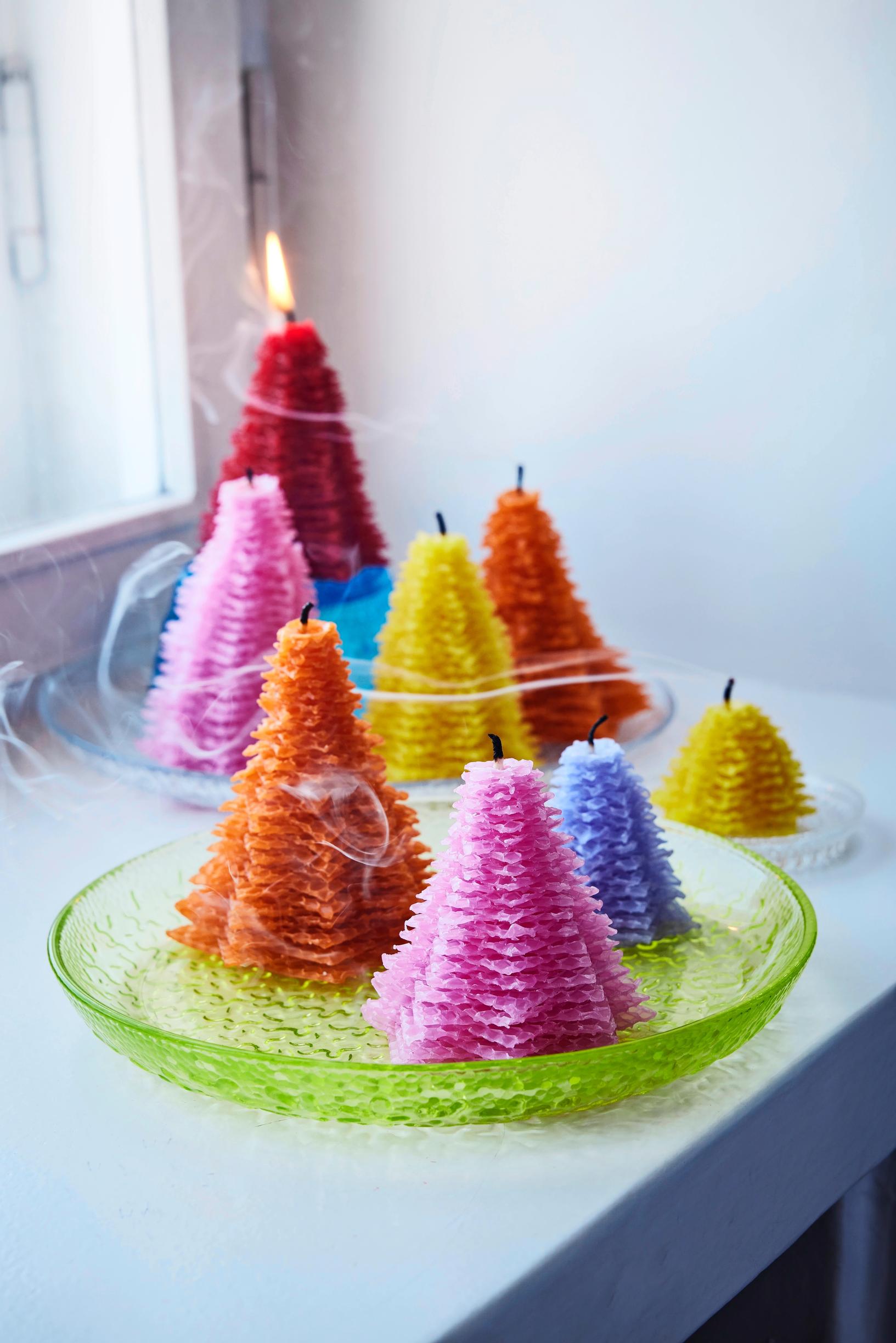 Colorful Christmas tree–shaped candles made from beeswax honeycomb sheets.