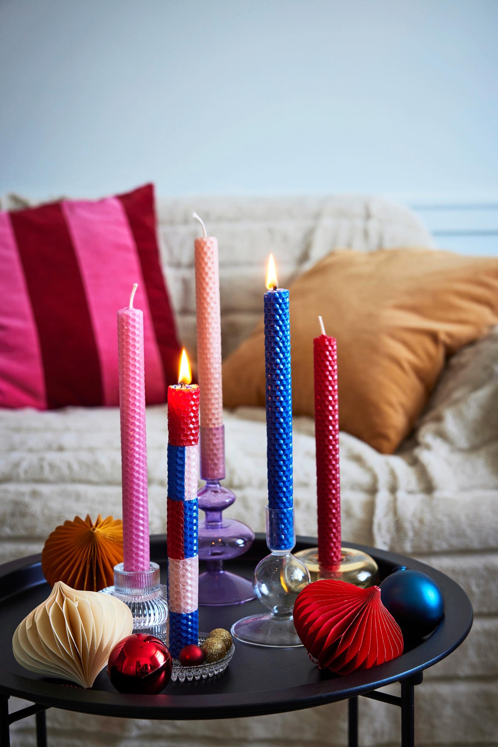 Colorful taper candles made from beeswax honeycomb sheets.