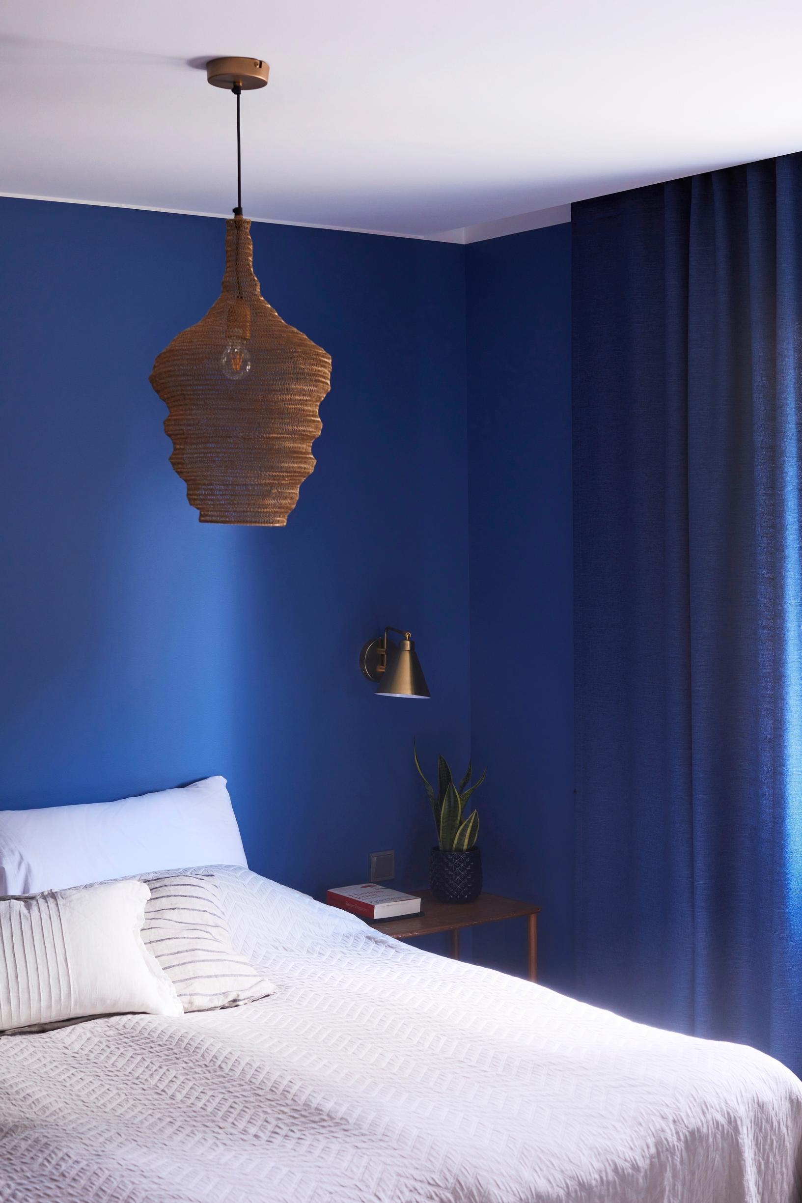 Curtains in the same shade as the dark blue bedroom walls