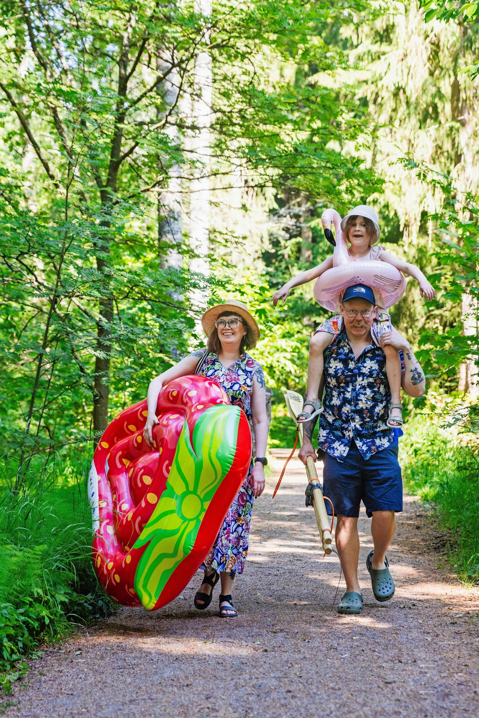 Elina Henttonen, Matilda, and Pasi on their way to the beach with an inflatable mattress