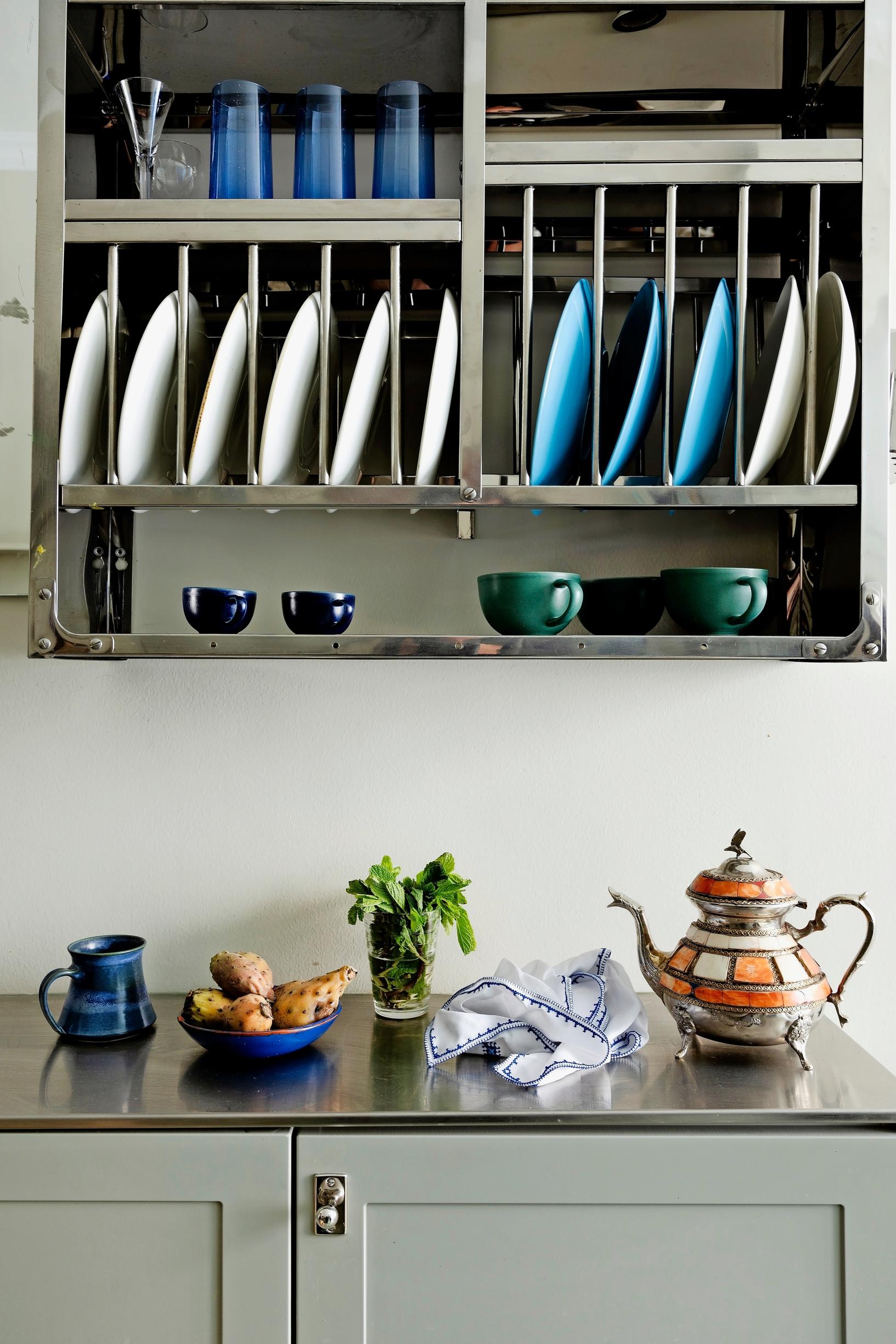 Image of a kitchen with a plate rack and stainless steel countertop.