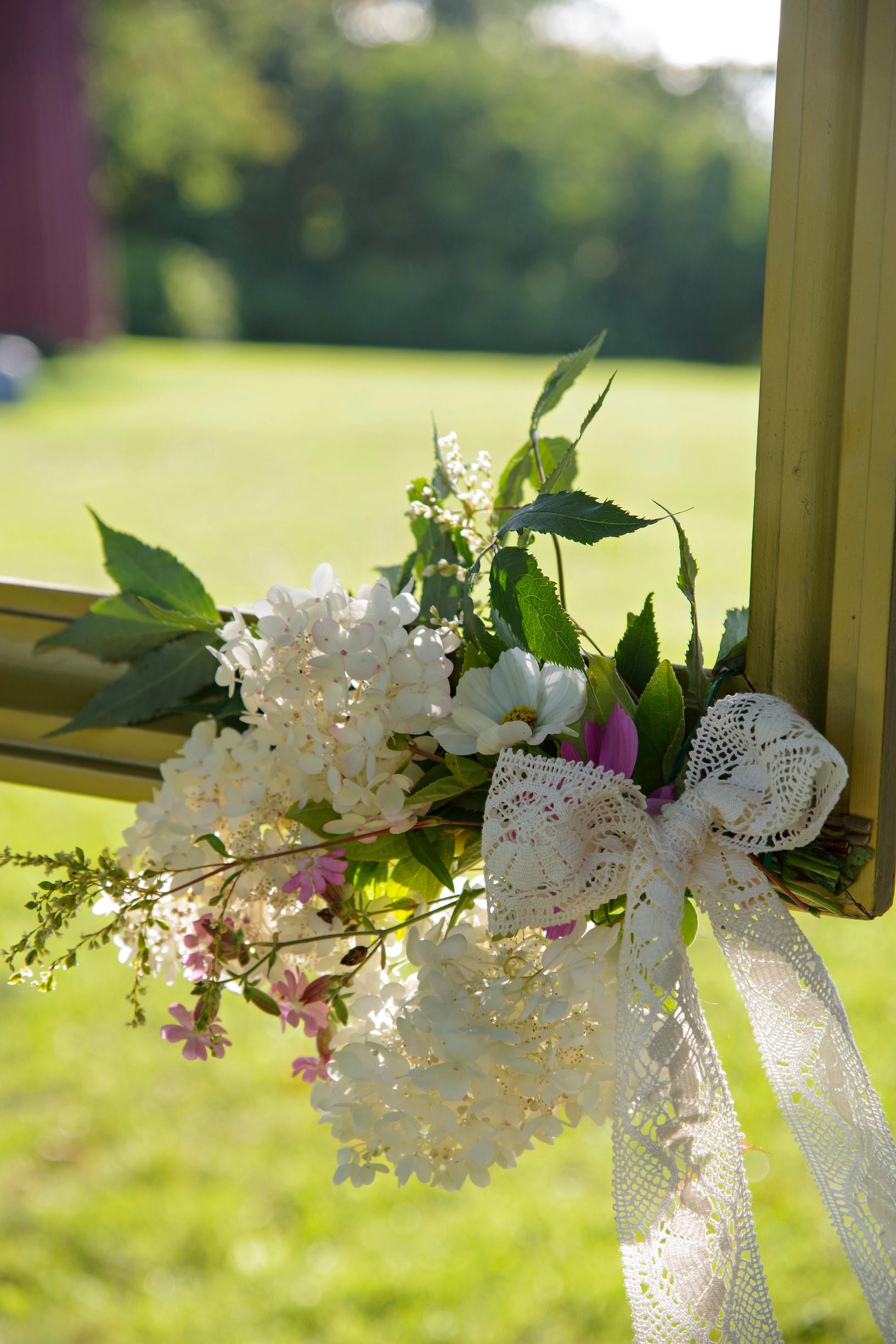Close-up of a small bouquet attached to the corner of the photo frame.