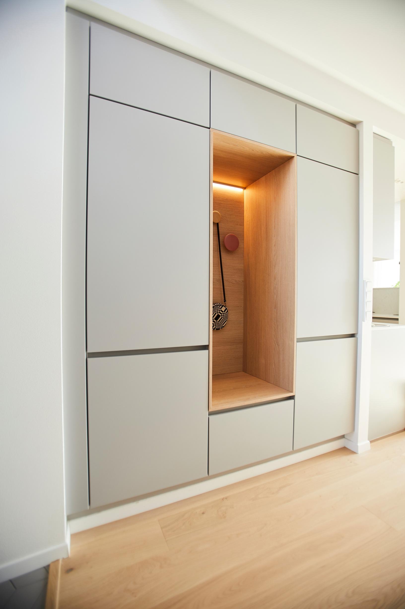 Built-in greige entryway cabinetry with a recessed bench