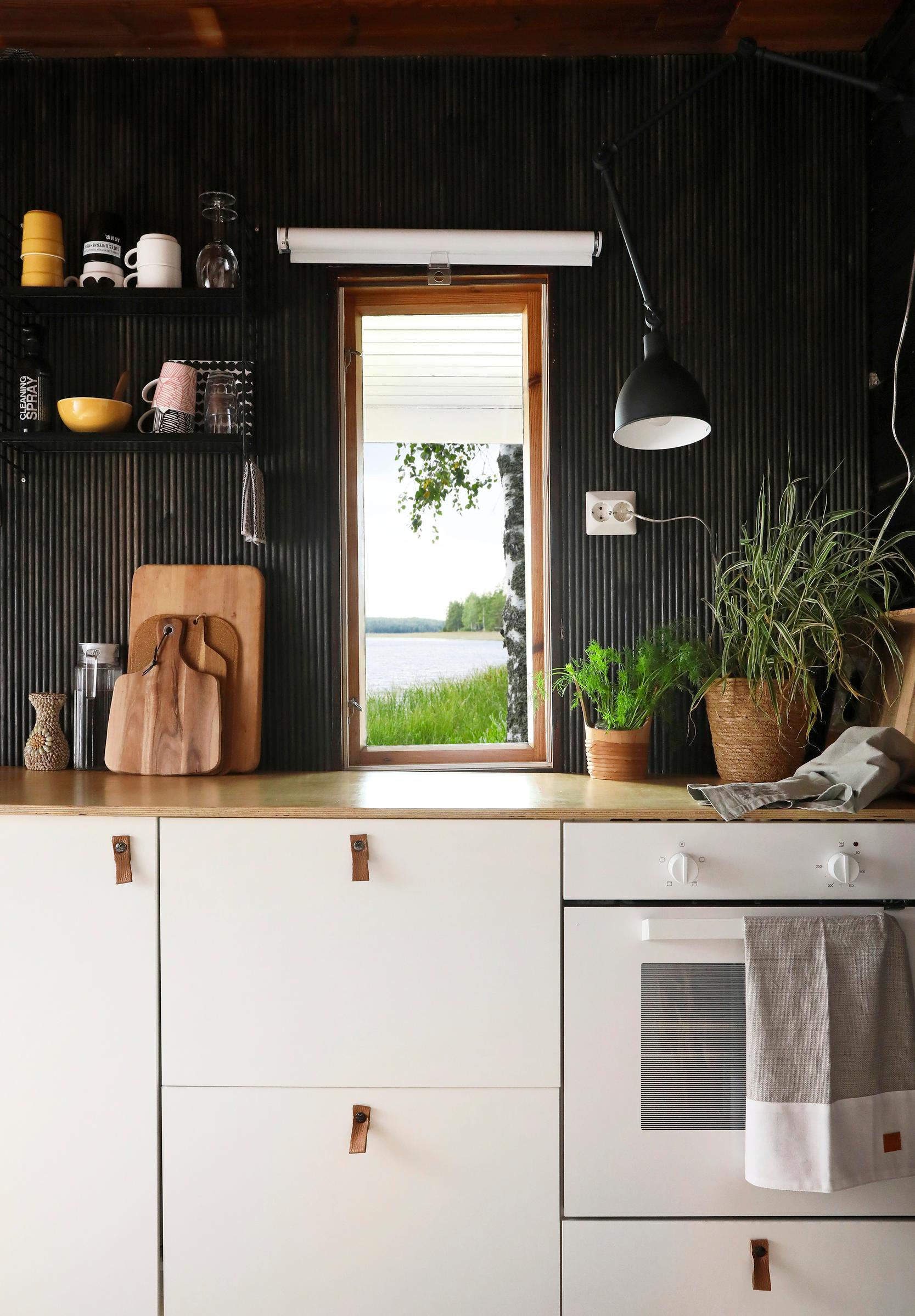 At a 1970s vacation cabin, a black finger-paneled wall in the kitchen