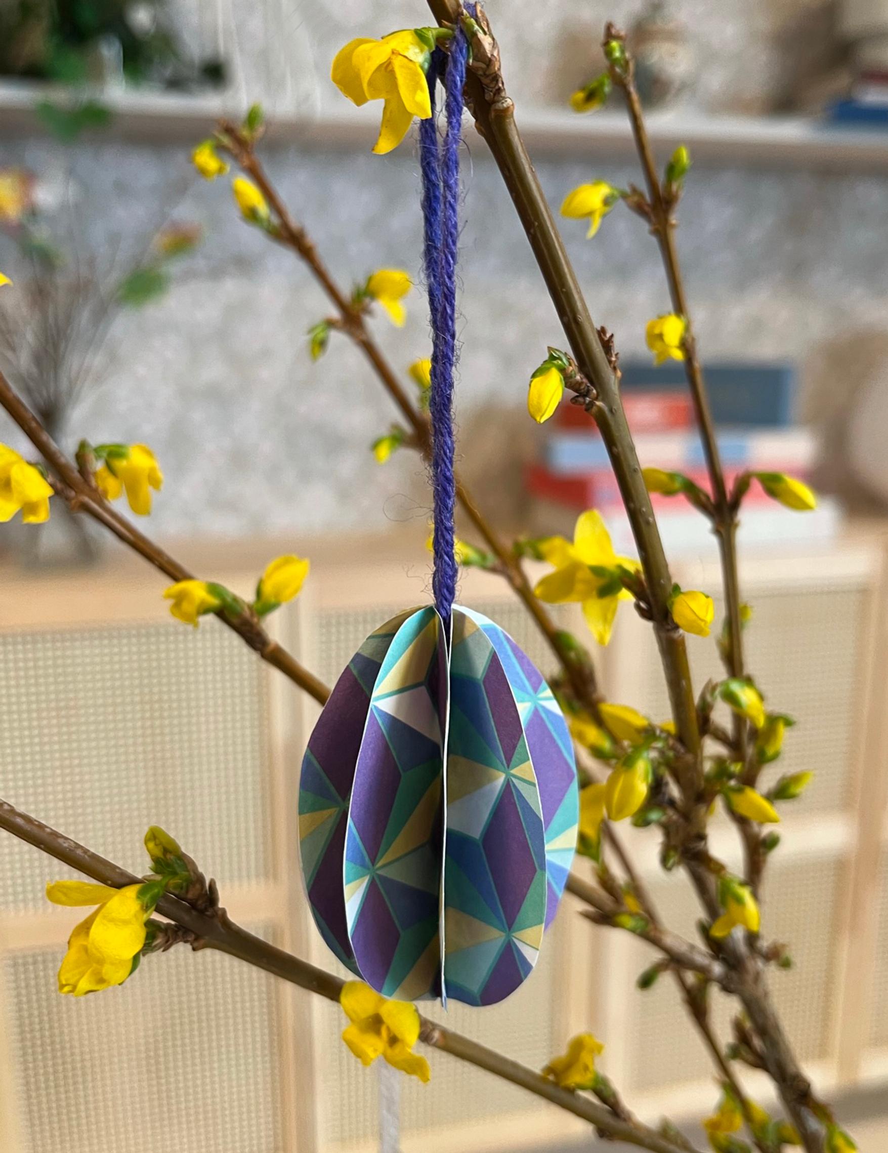 A small paper Easter egg on a branch