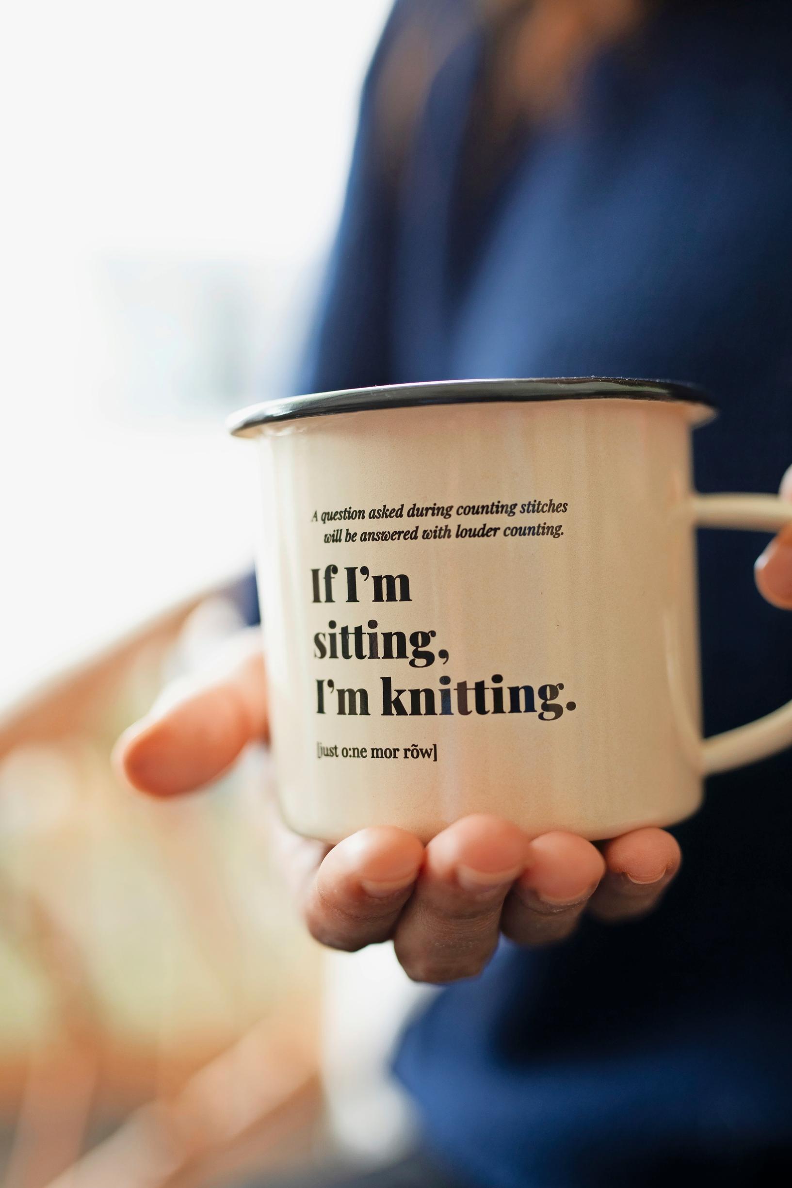 Mug with the text: ‘If I’m sitting, I’m knitting.’