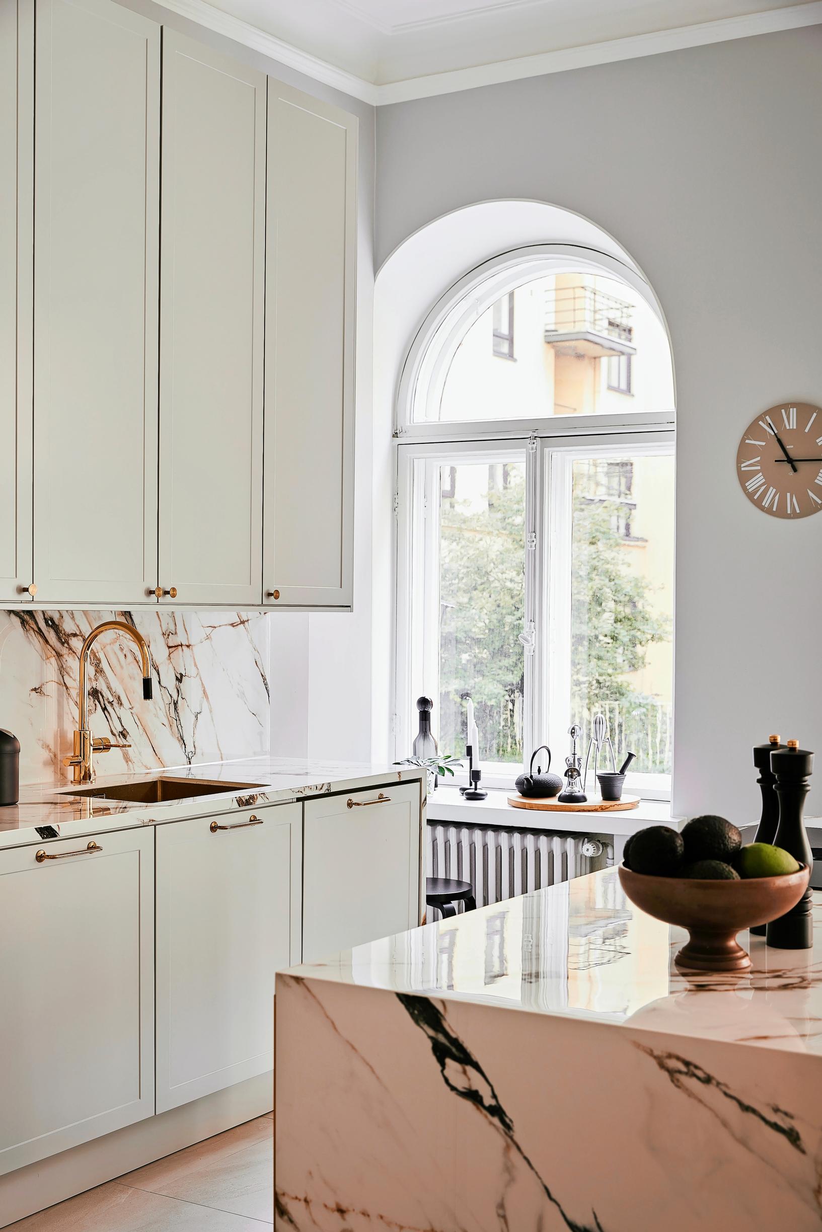 Arched windows and marble-patterned large-format tile in the kitchen