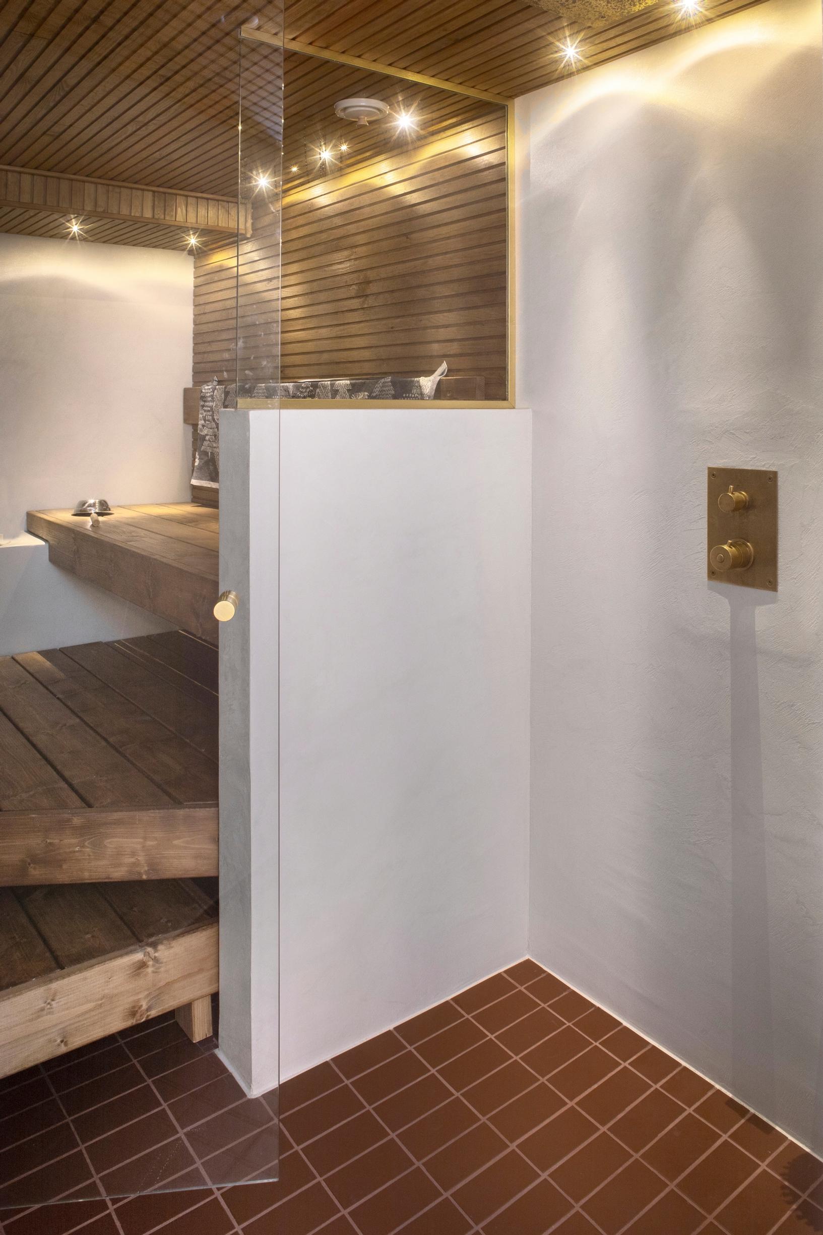 A glass-walled sauna for two with an overhead shower.