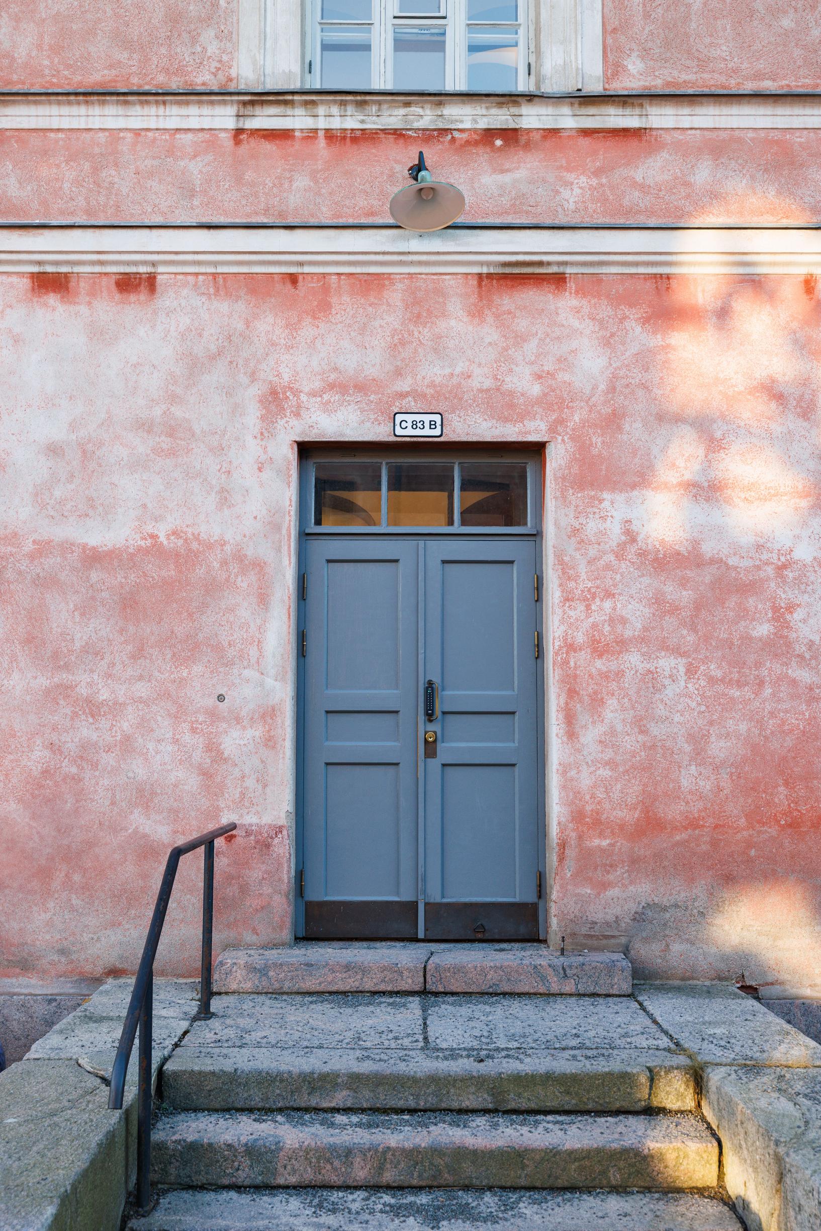 a blue door in a pink building in Suomenlinna