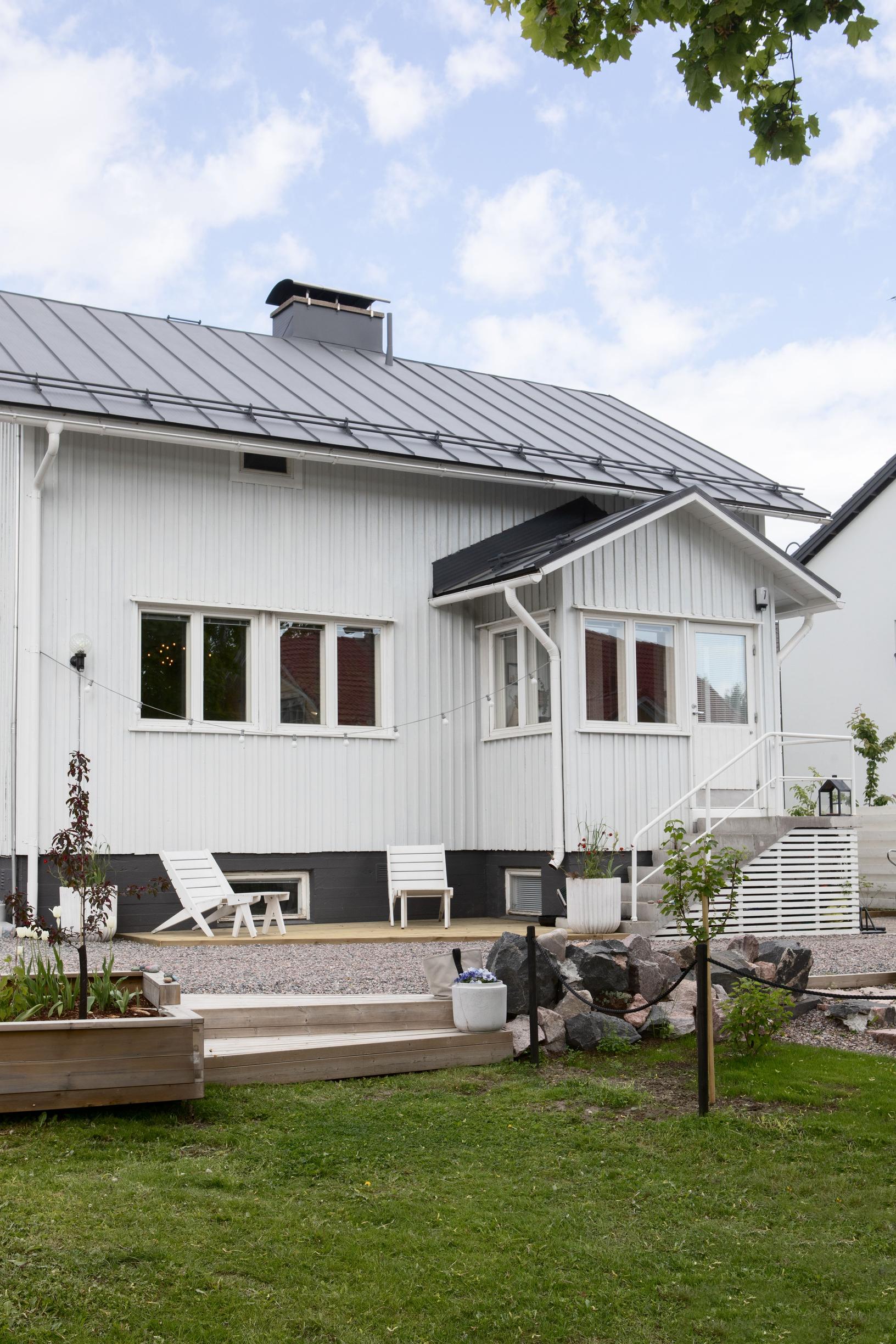 The yard and terrace of the wooden post-war home.