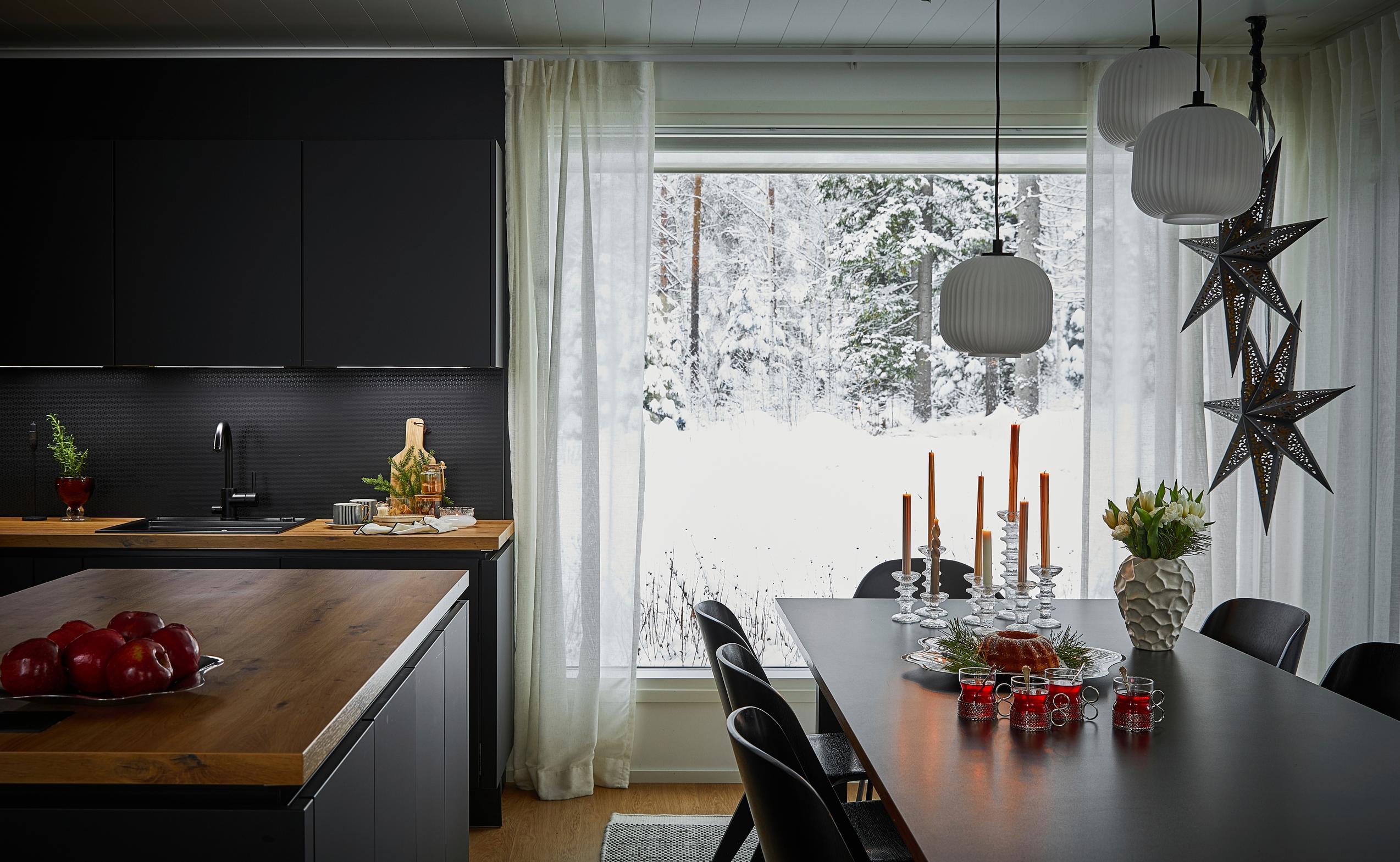 dining set decorated for Christmas and a black-brown kitchen with an island