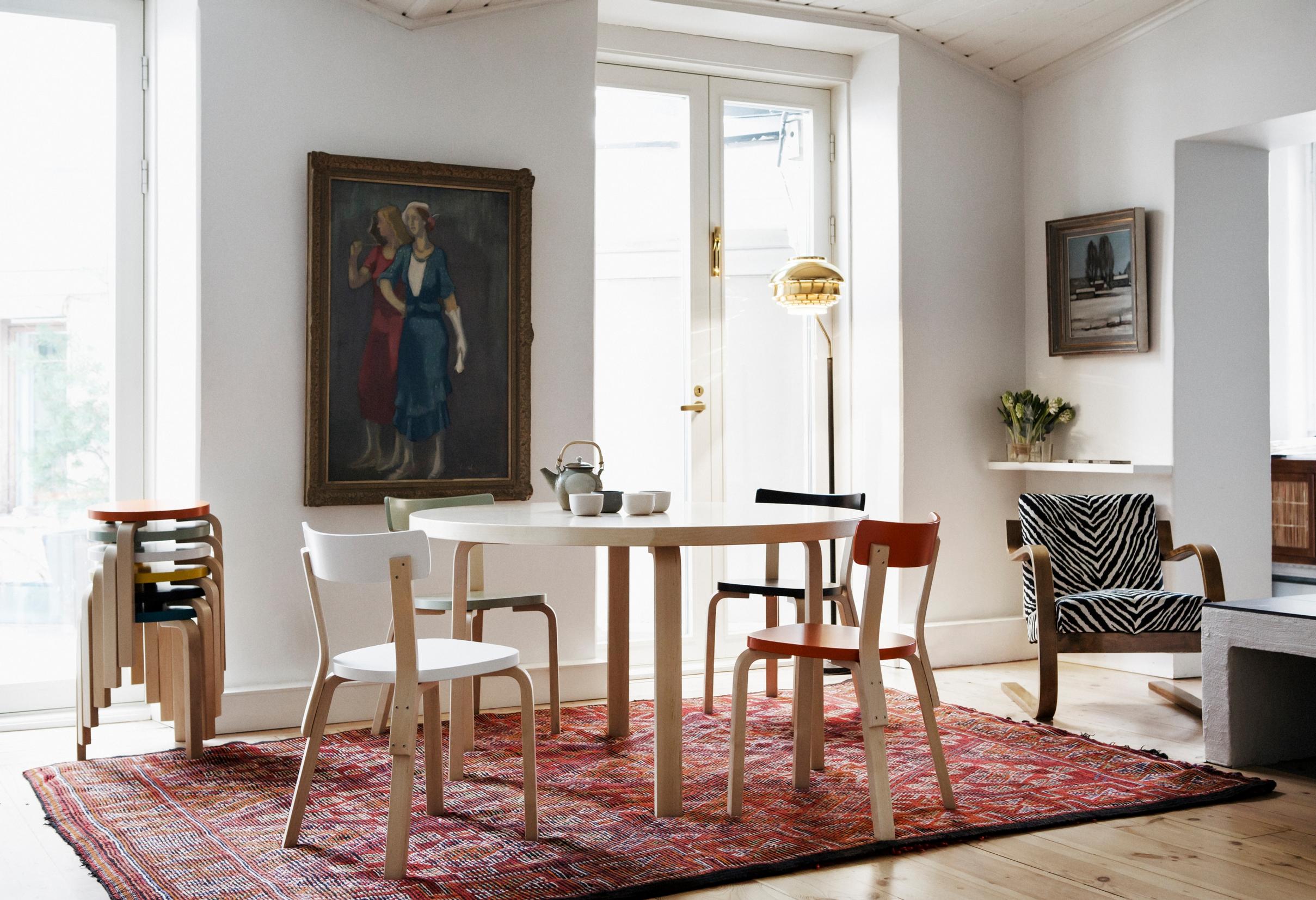 Red-toned nomadic rug under an Artek dining set