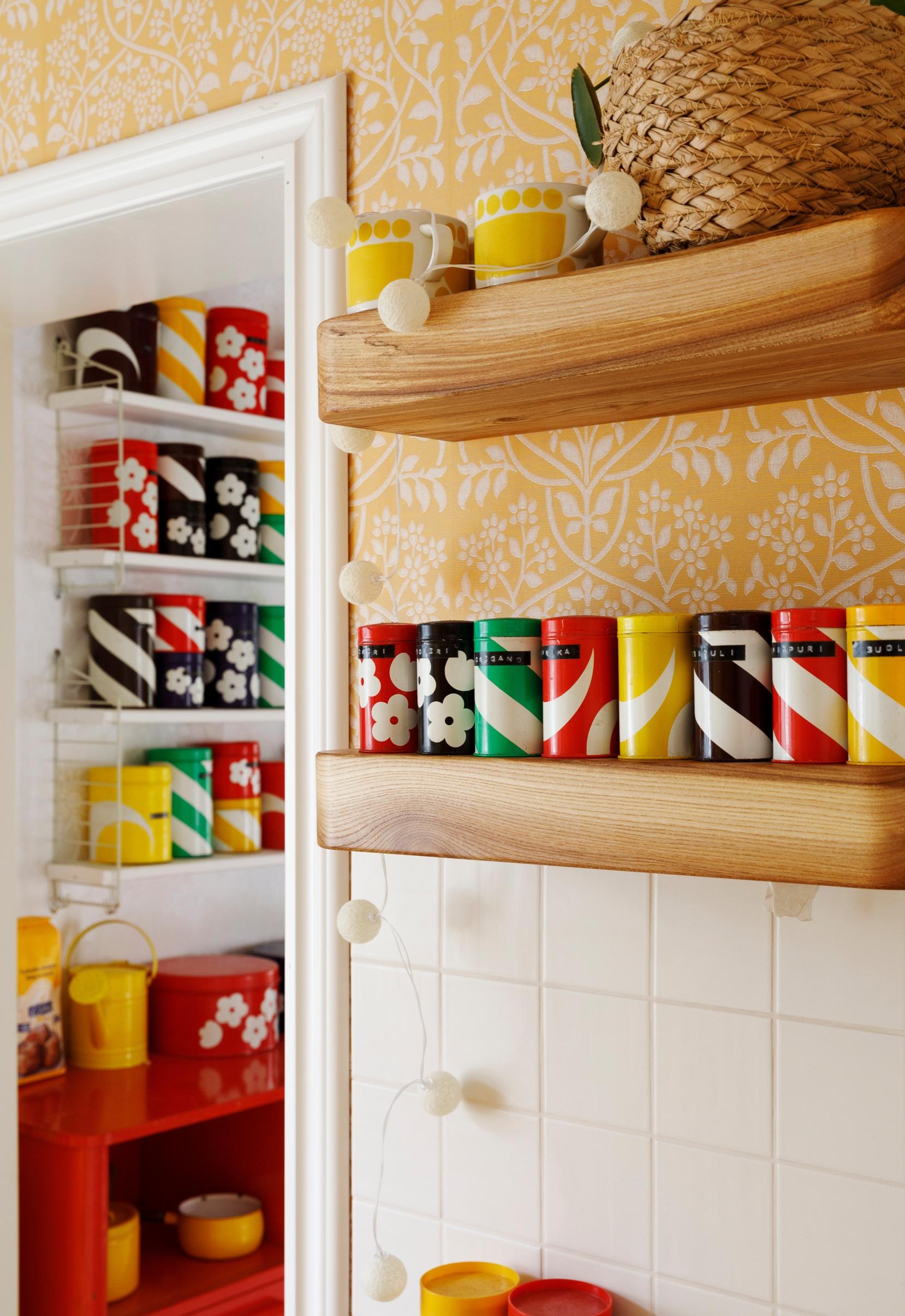 Colorful Aarikka tin containers on wooden shelves