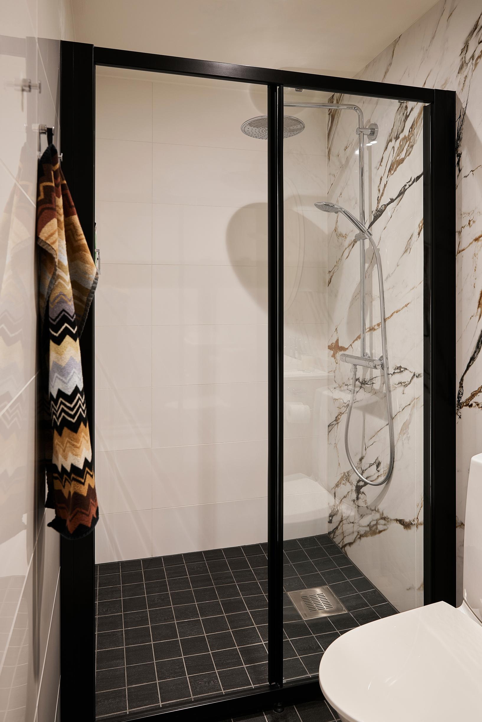 A black-framed shower wall