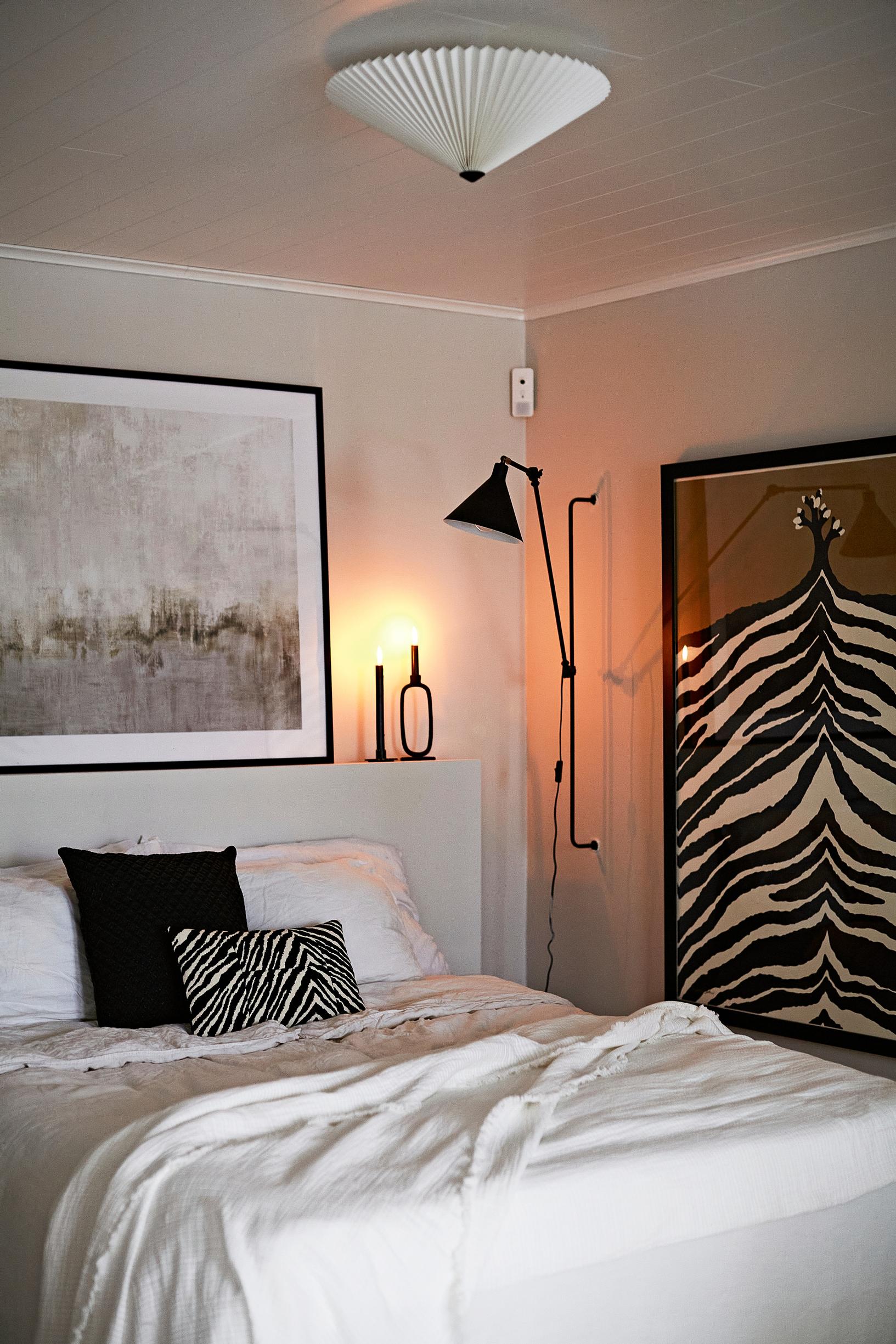 bedroom, bed, wall lamp, pictures, and a ceiling lamp