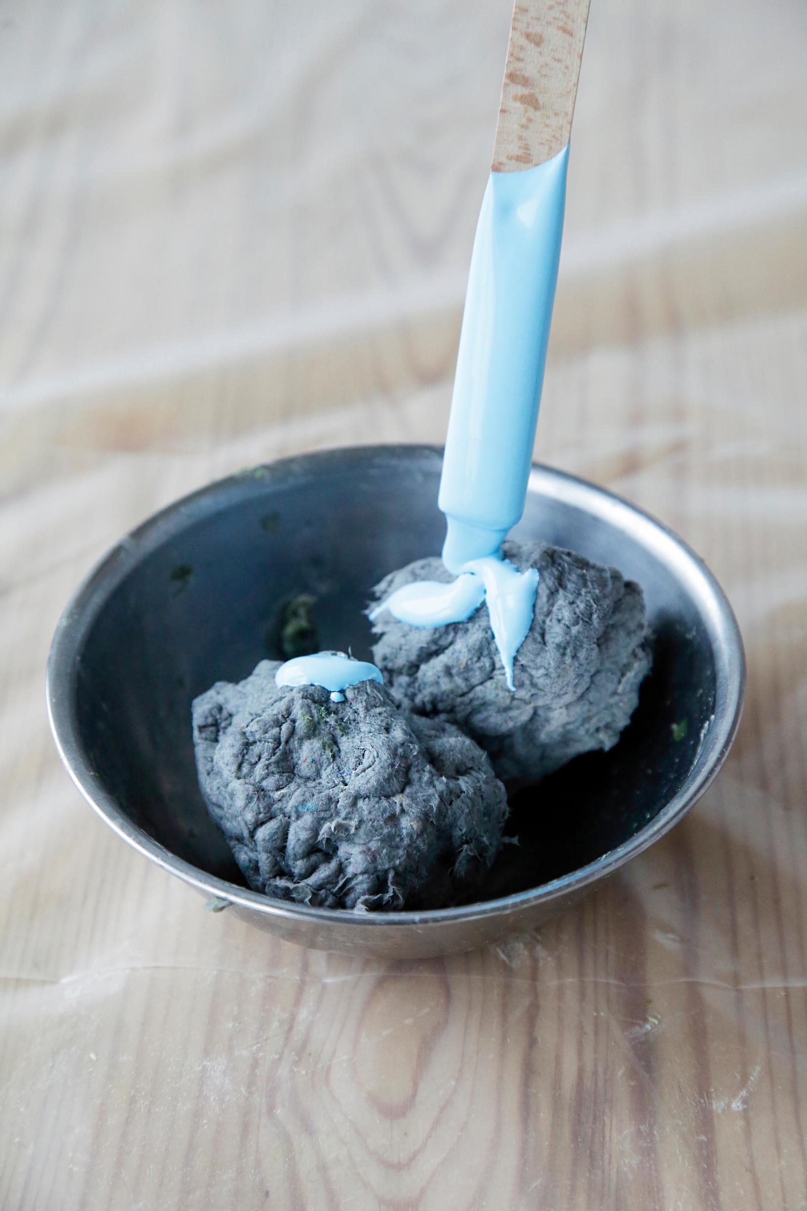 Coloring a ball of papier-mâché.