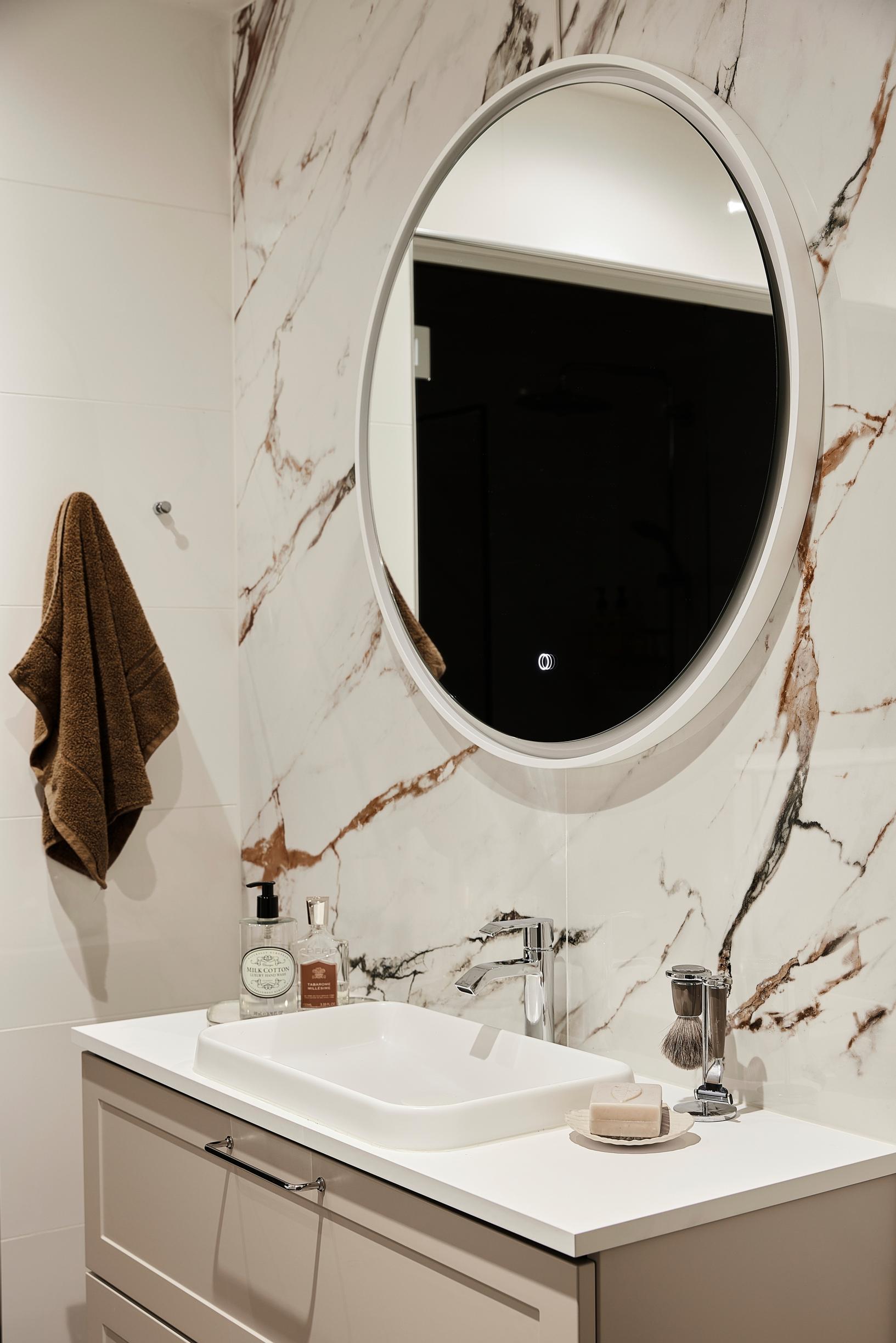 Marble-patterned Calacatta large-format tile behind the vanity