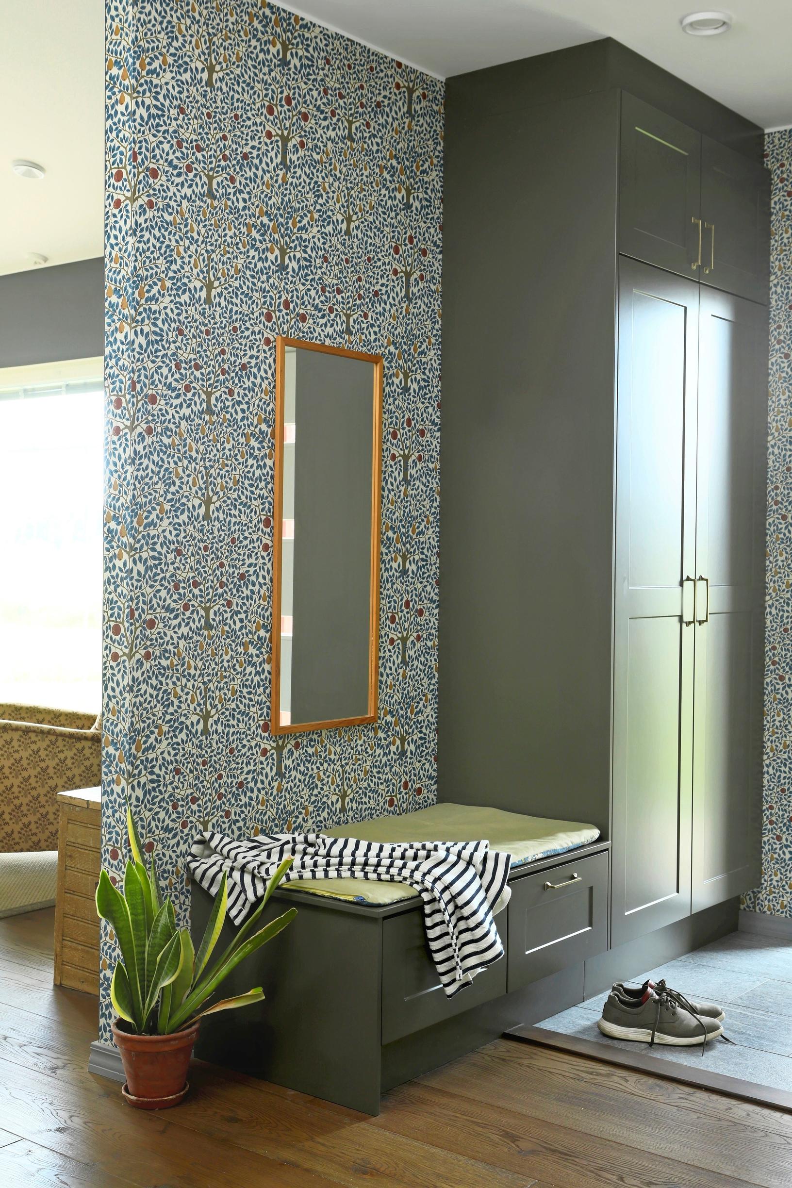 Hallway with a tall wardrobe and built-in bench. There’s a mirror above the bench.