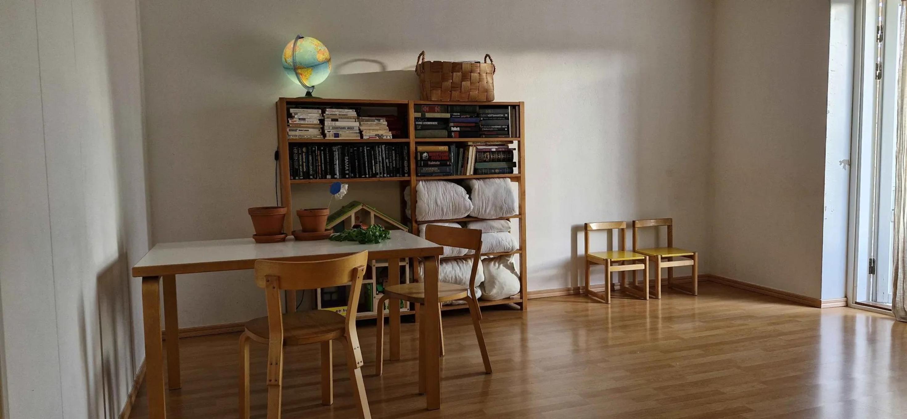 living room with a dining table, a bookcase, and four chairs