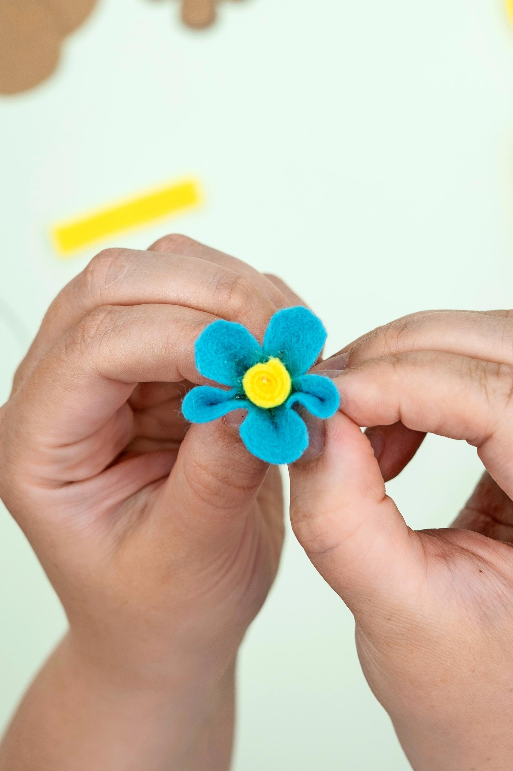 Small flowers form from a rolled center and a scalloped petal piece.