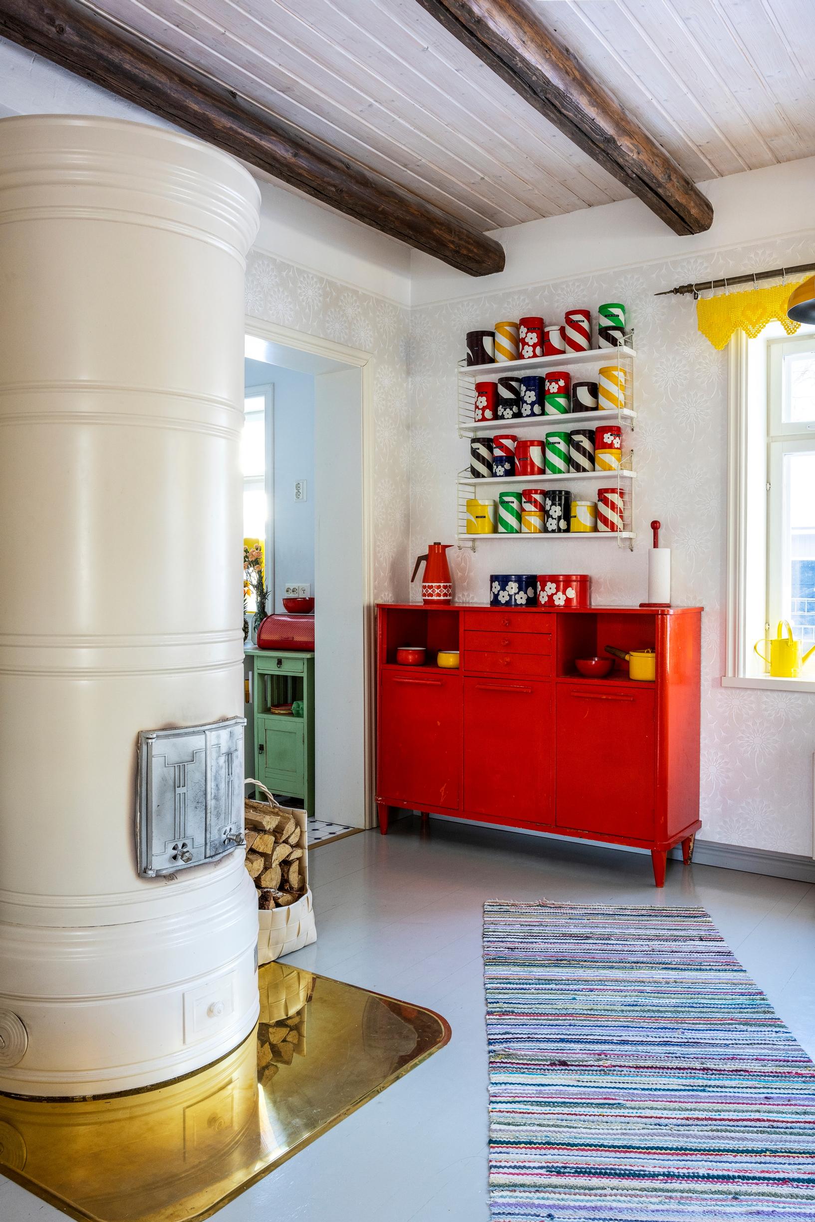 A wood-burning stove and a red display cabinet.