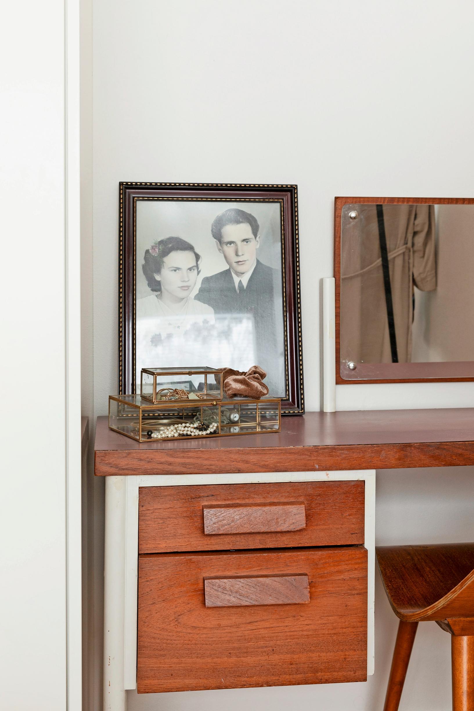 Photo of a 1960s teak dressing table with her grandparents’ black-and-white wedding photo on top.