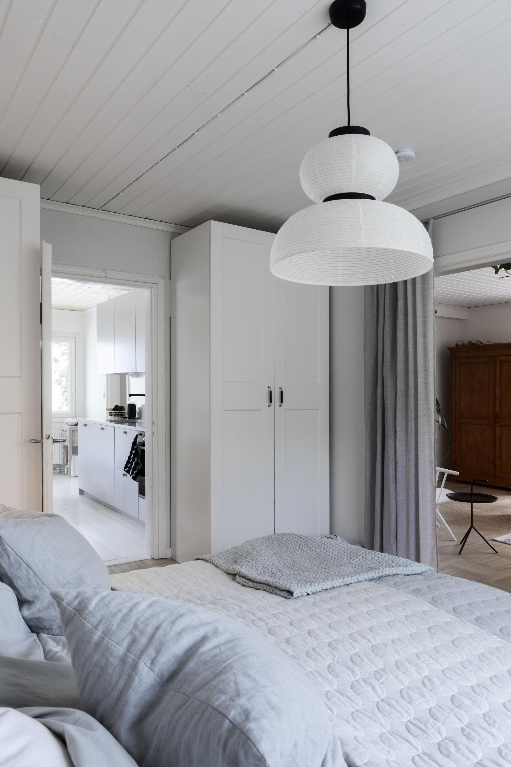 Bedroom with a wardrobe in the corner. View into the kitchen.