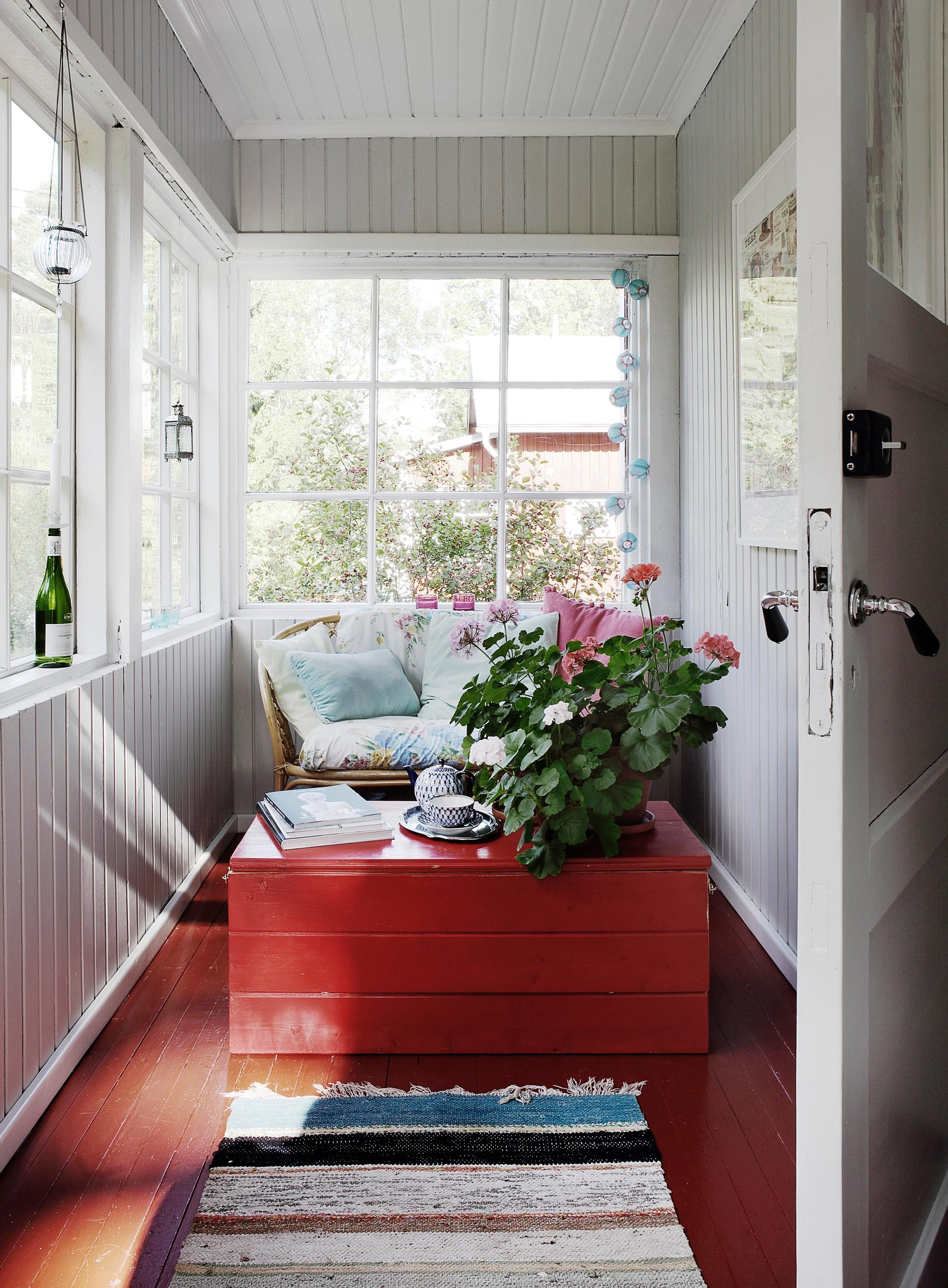A glass porch with a red floor