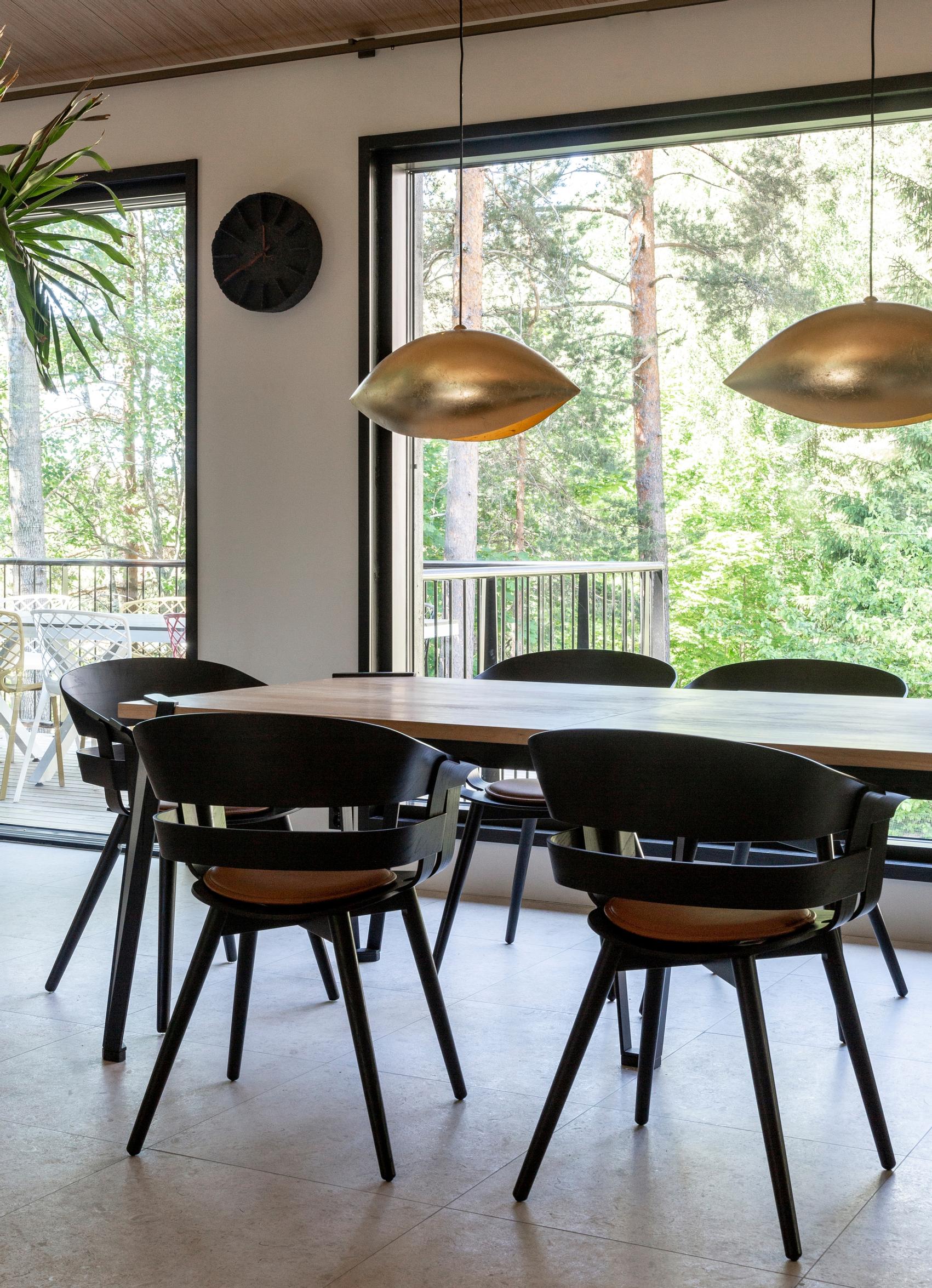 Dining table designed by Aino and chairs with armrests.