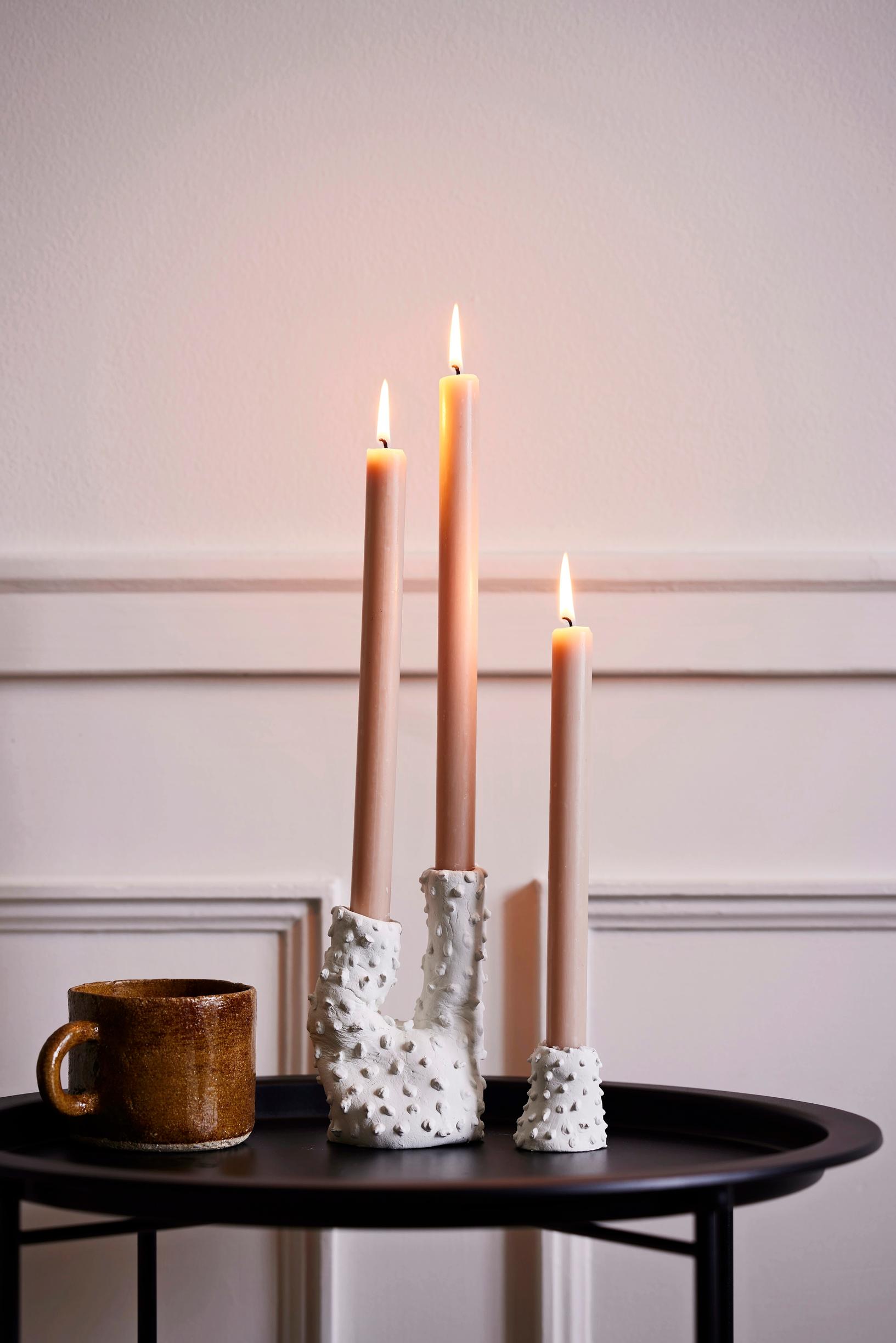 Coral‑like candle holders on a table.