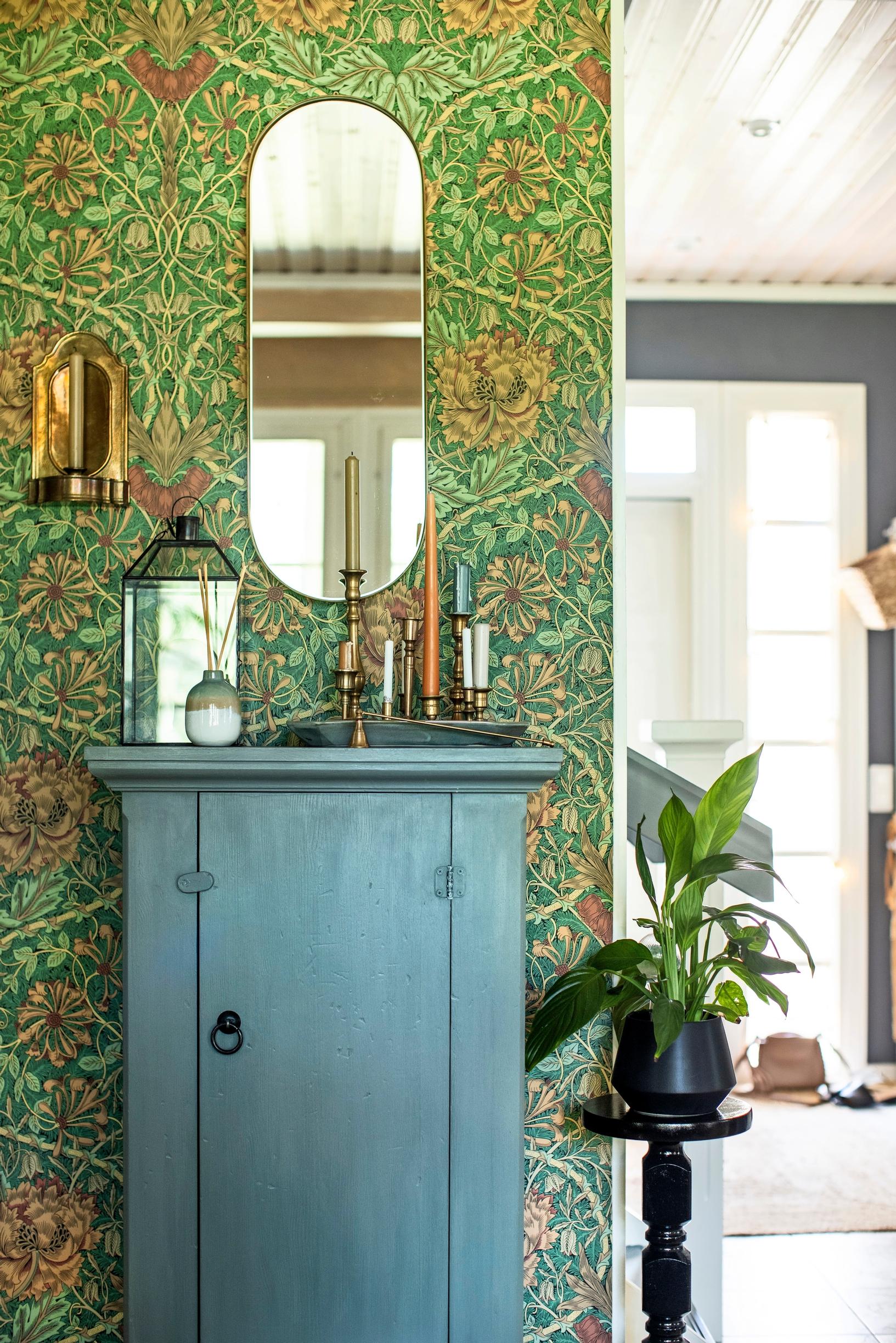 William Morris floral wallpaper behind an old cabinet