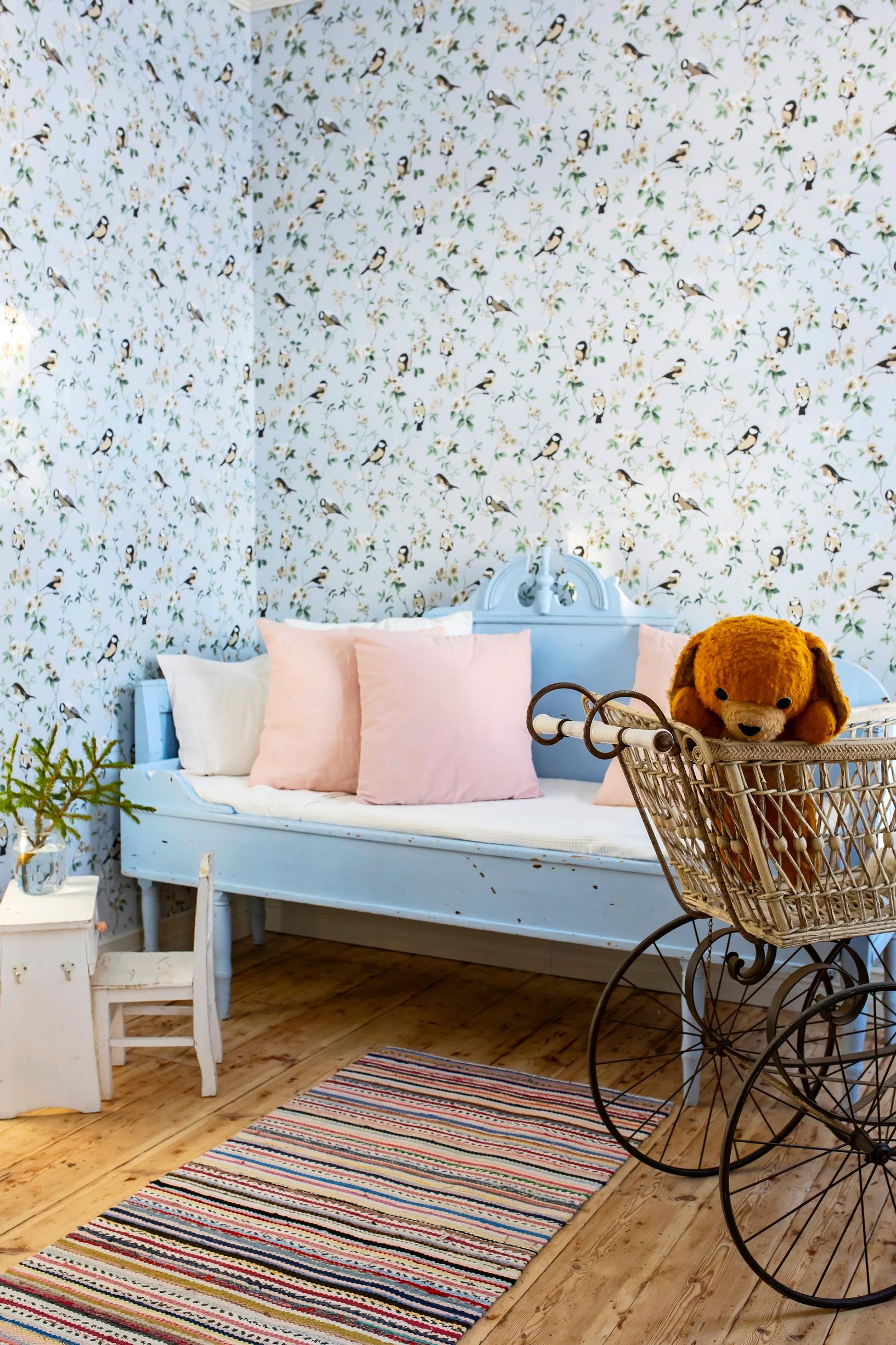 A pastel-toned children’s room decorated with old furniture