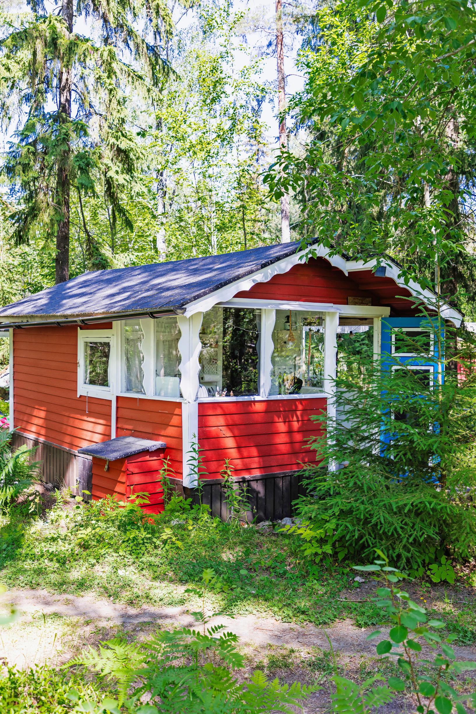 a red summer cabin and forest