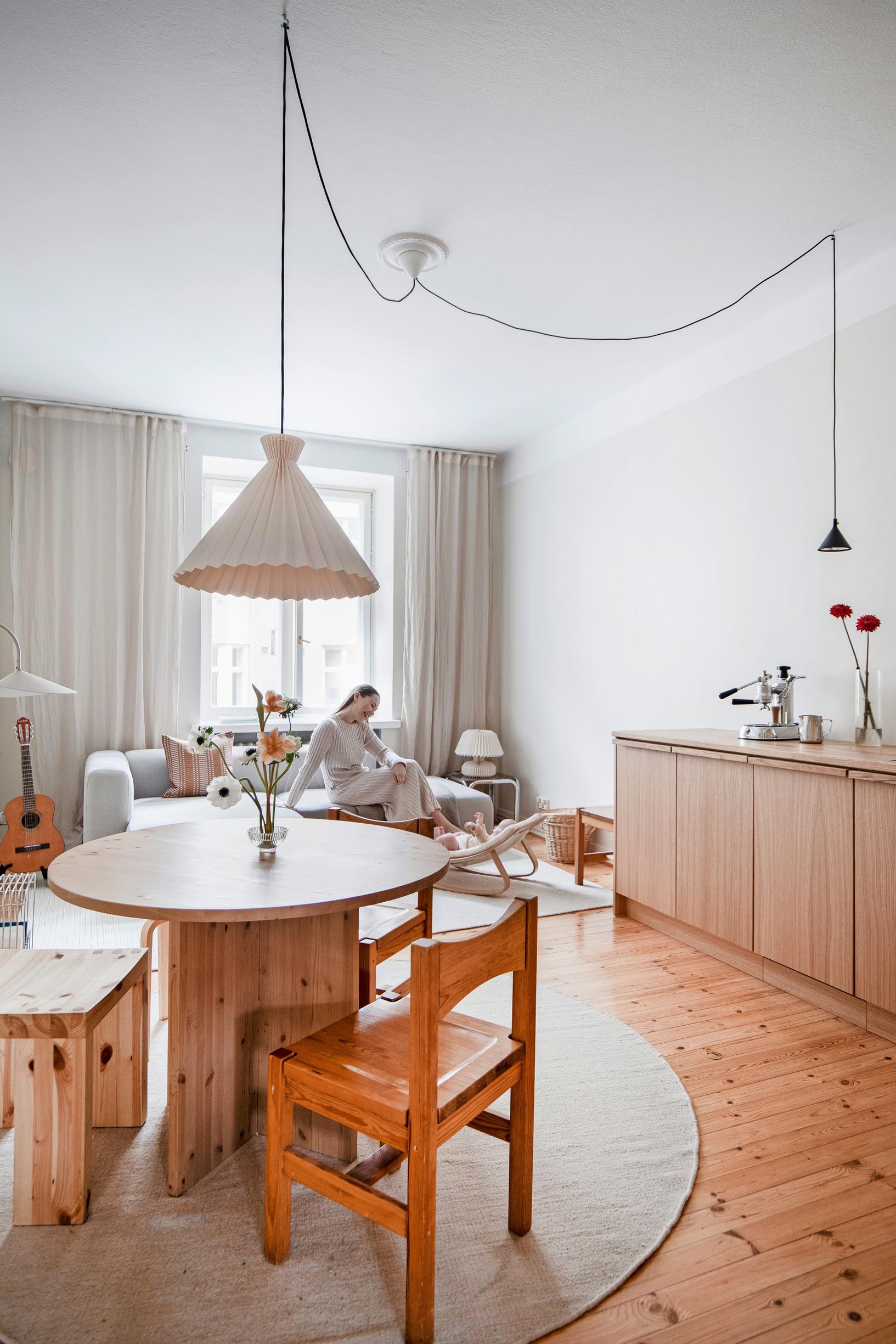 A round dining table made of Finnish pine with sturdy wooden chairs