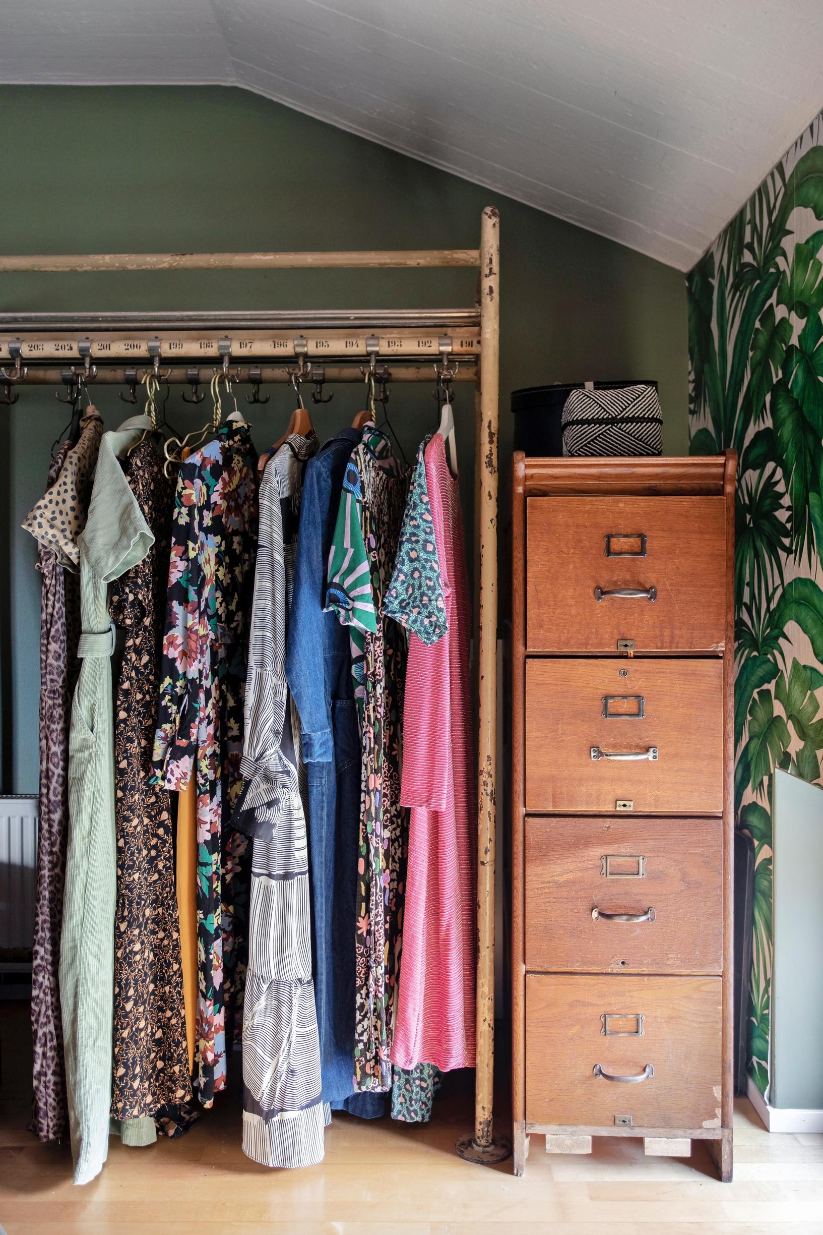 Clothes on a wooden rack and a repurposed filing cabinet.