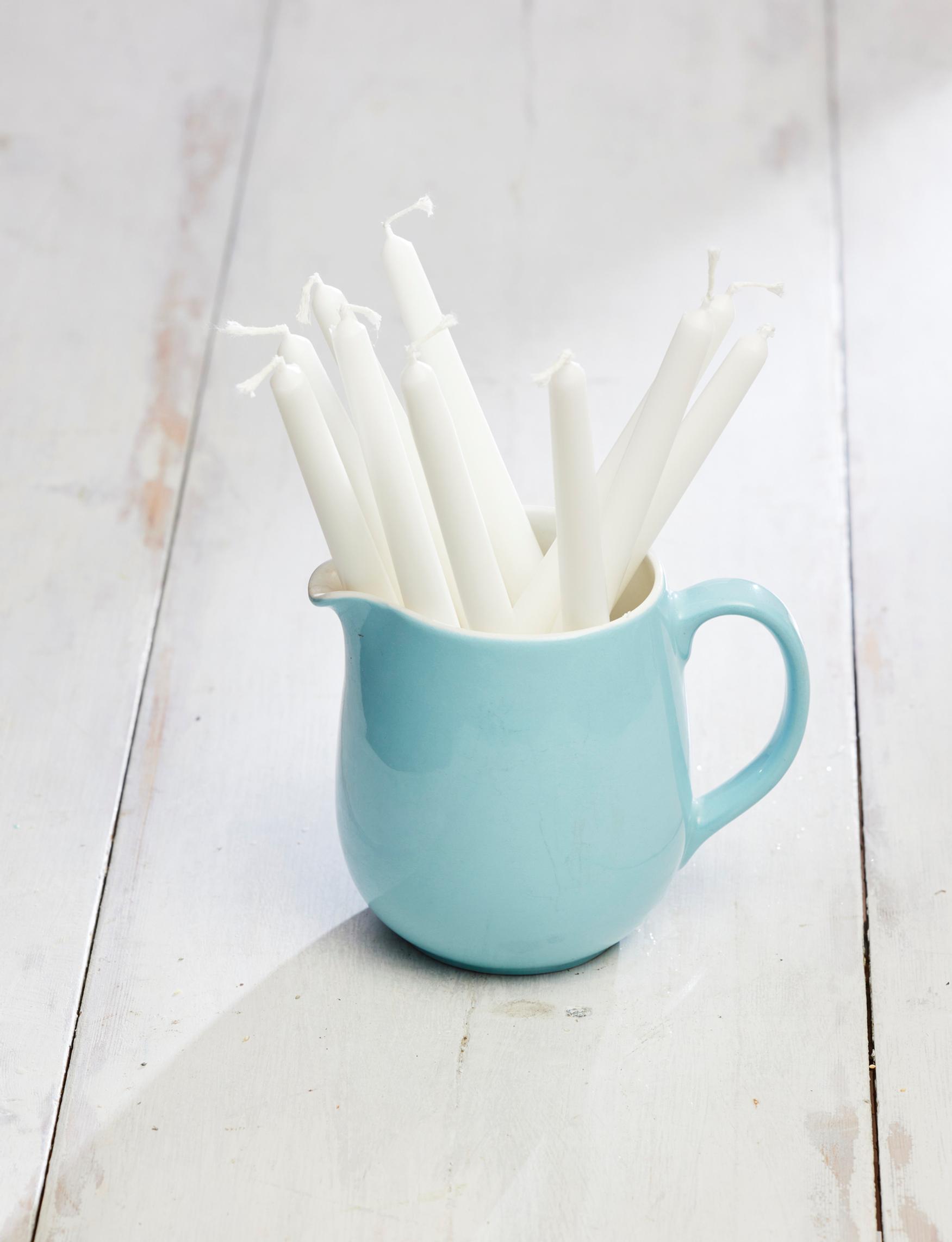 An old Arabia milk pitcher holding candles.