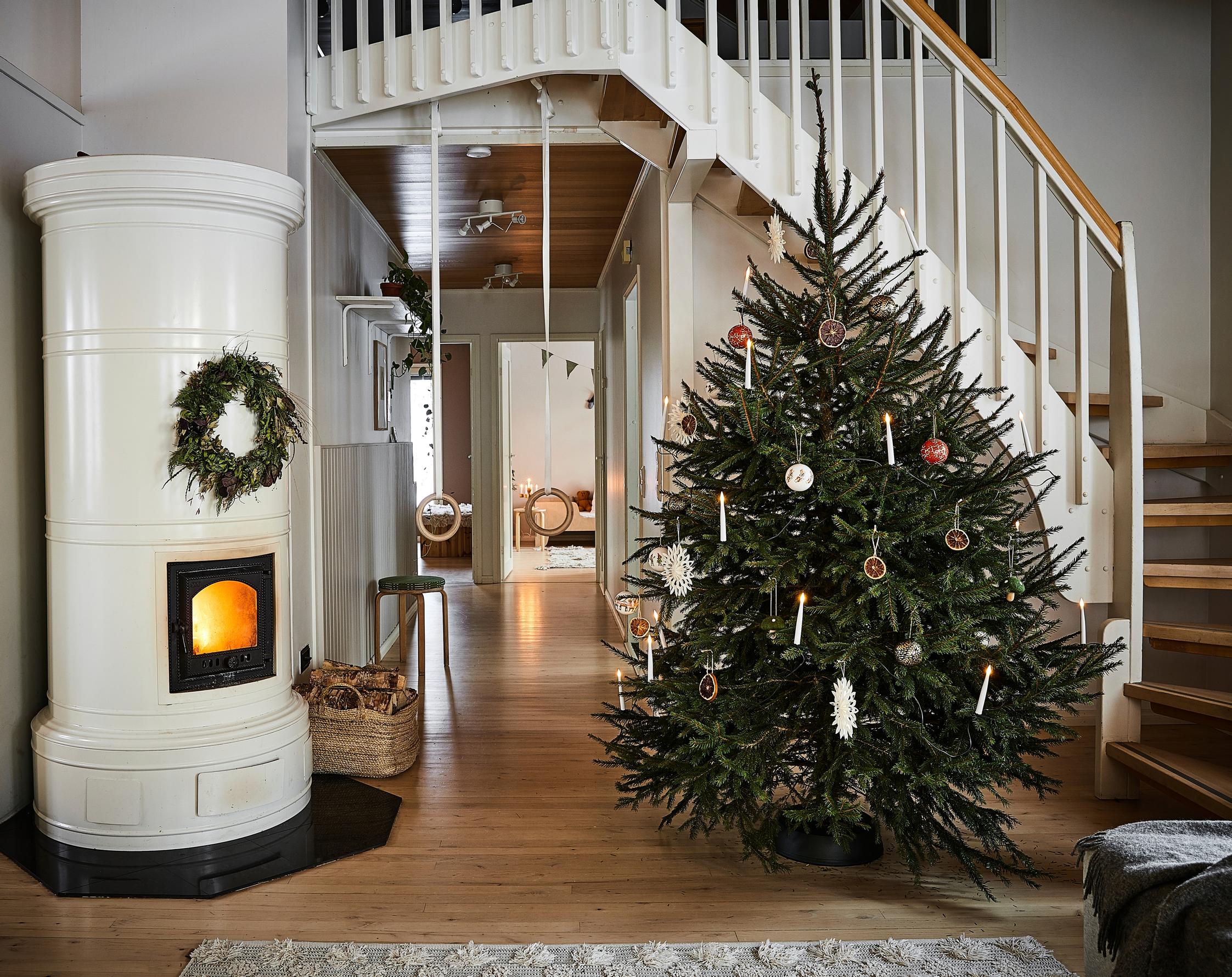 A fire in the wood-burning stove, a Christmas tree, and stairs leading upstairs