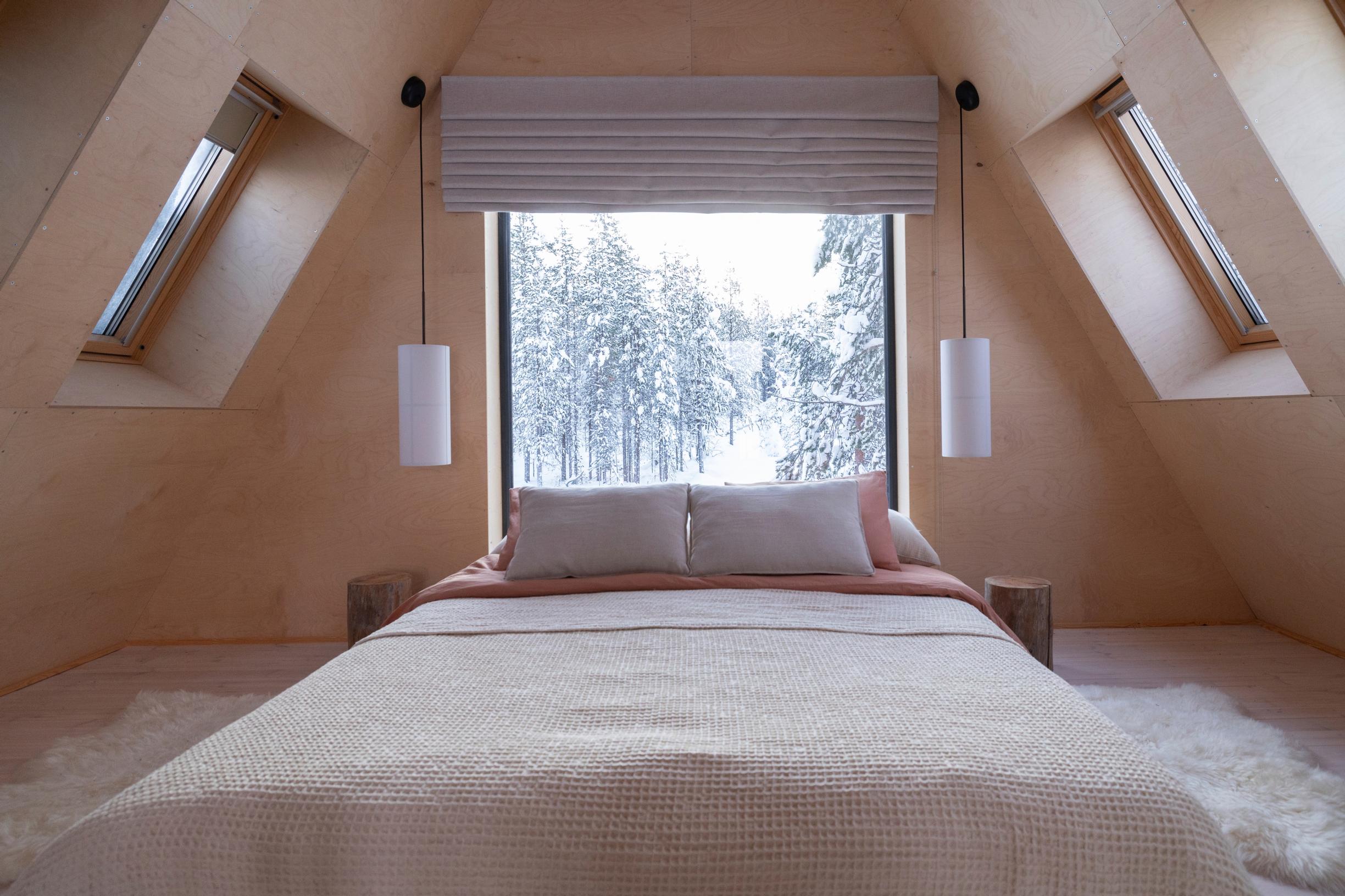 Landscape windows in the slanted ceiling and the gable wall in the minimalist bedroom