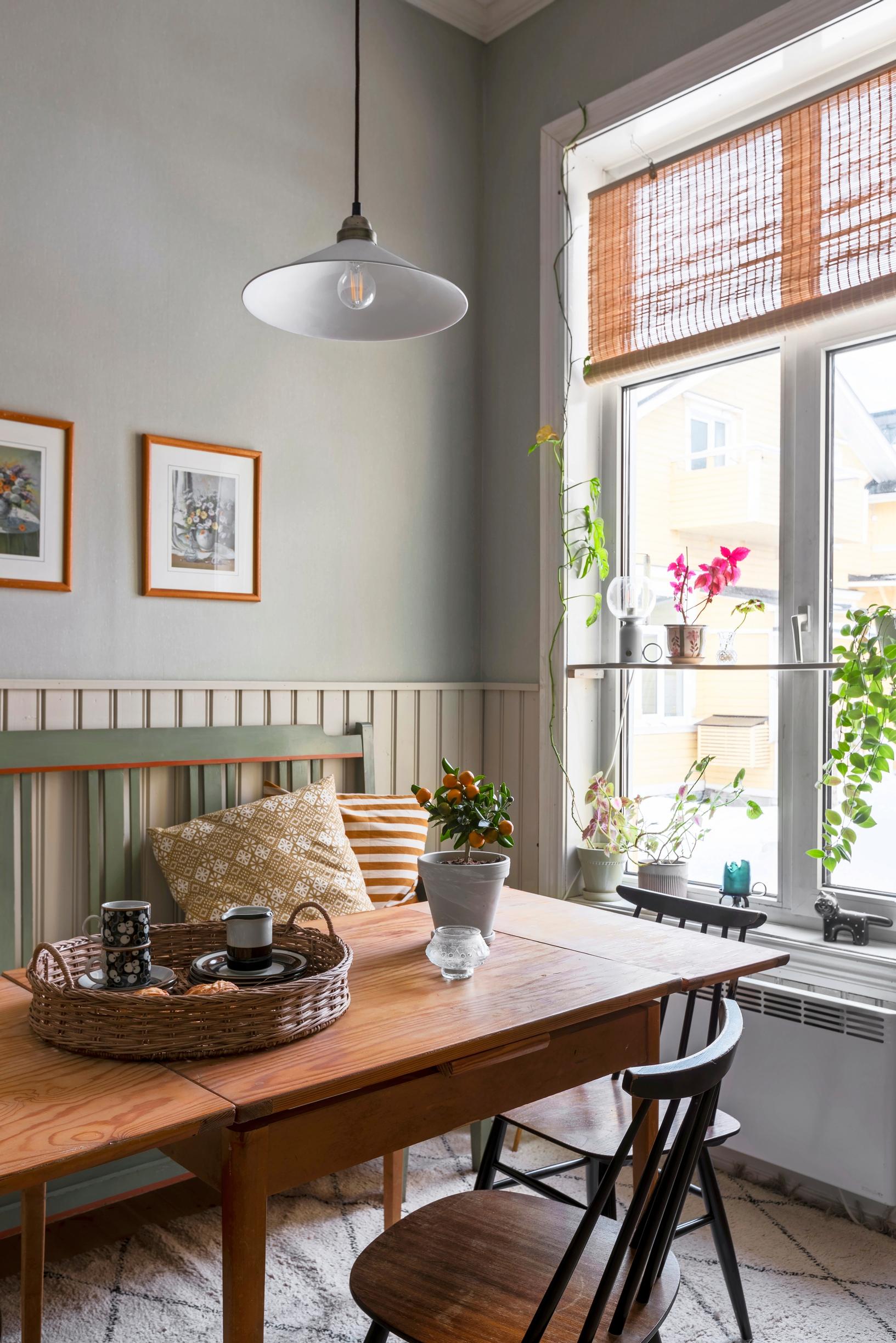 Plants and decorative items on shelves attached to the kitchen windows.