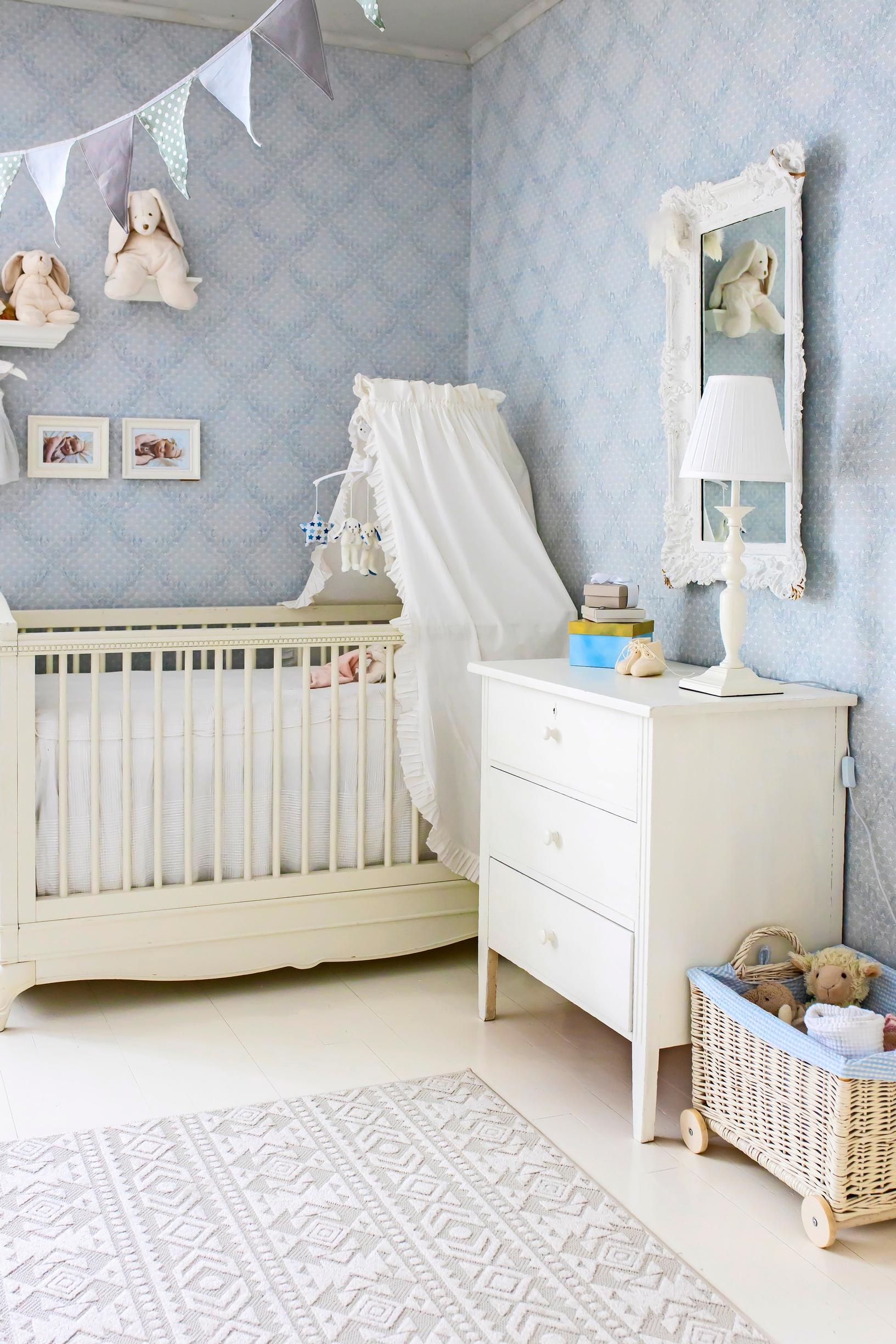 A crib and an old dresser in the corner of the baby’s room.