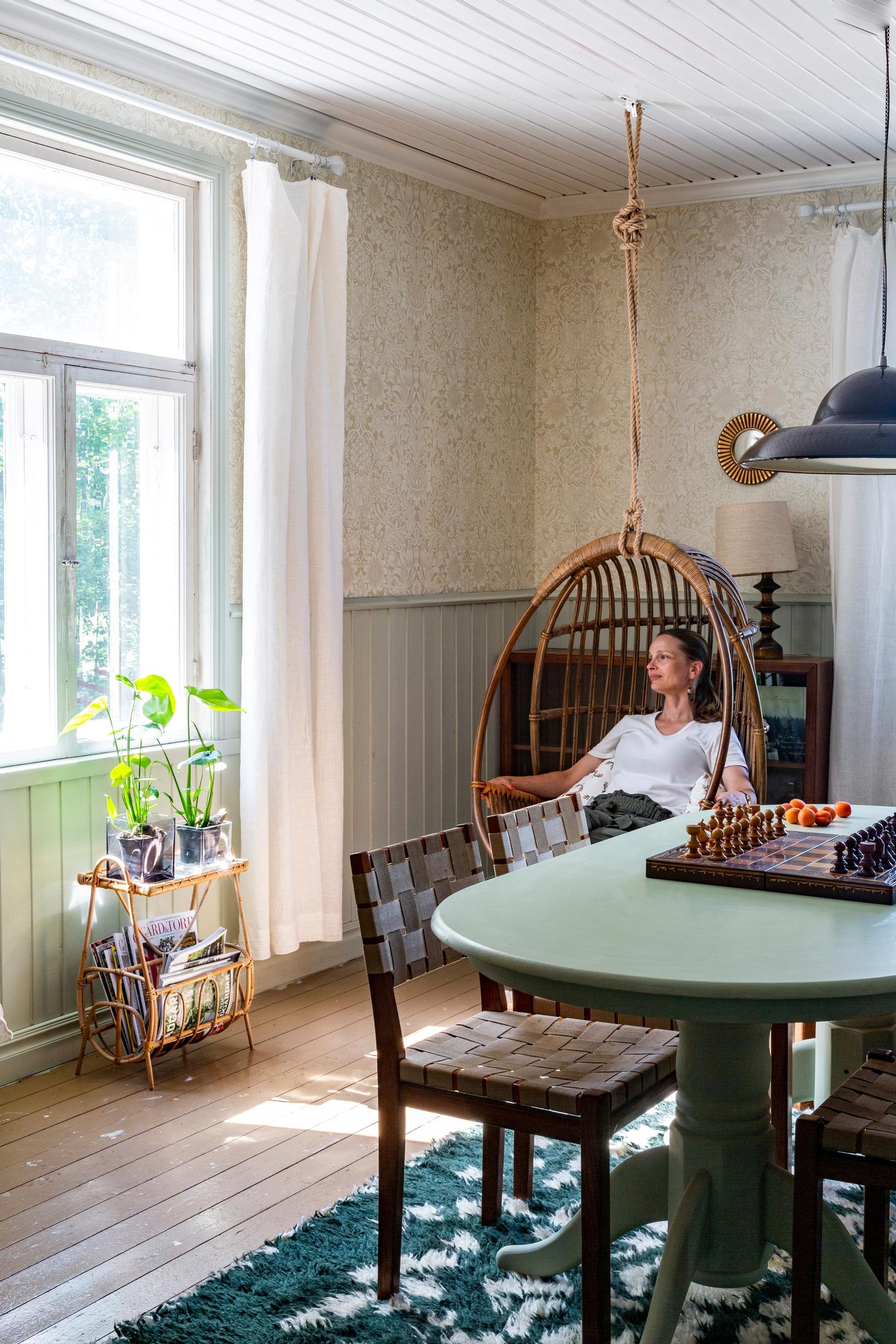 A rattan hanging chair by the window.