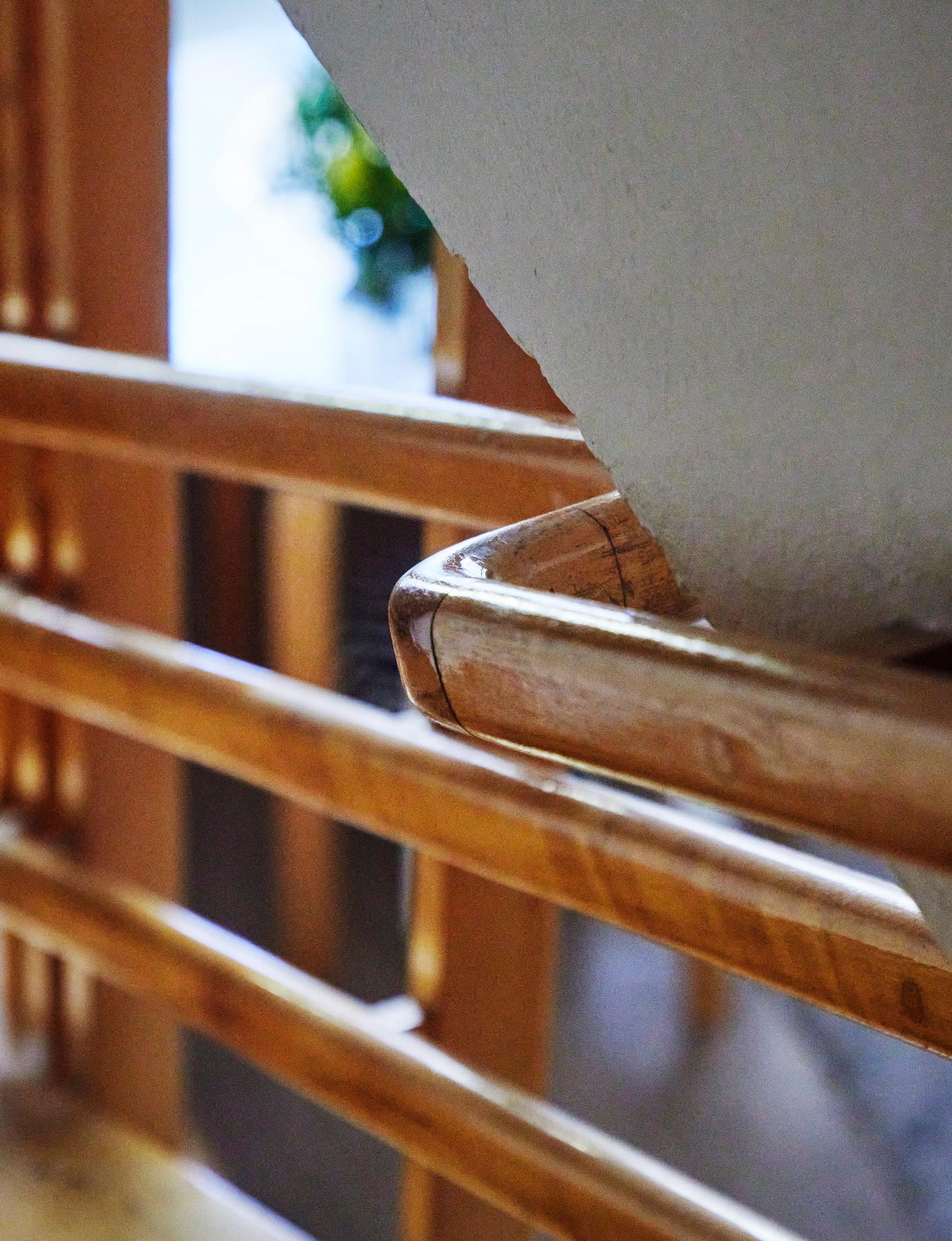 The staircase features sculptural details, including three handrails.