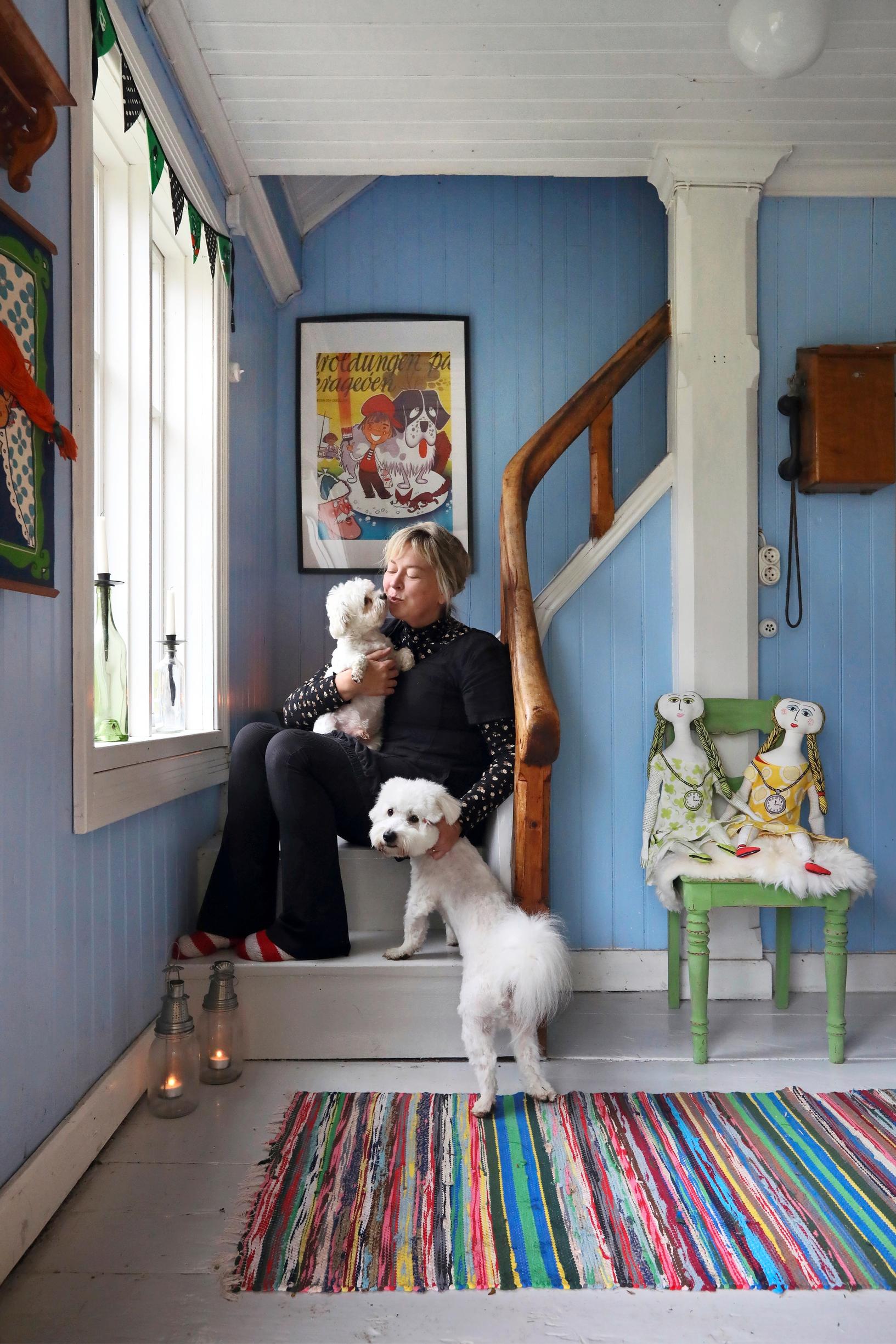 Nina Kiuru in the entrance hall of the Åland family estate. Stairs, rag rugs, and old items.