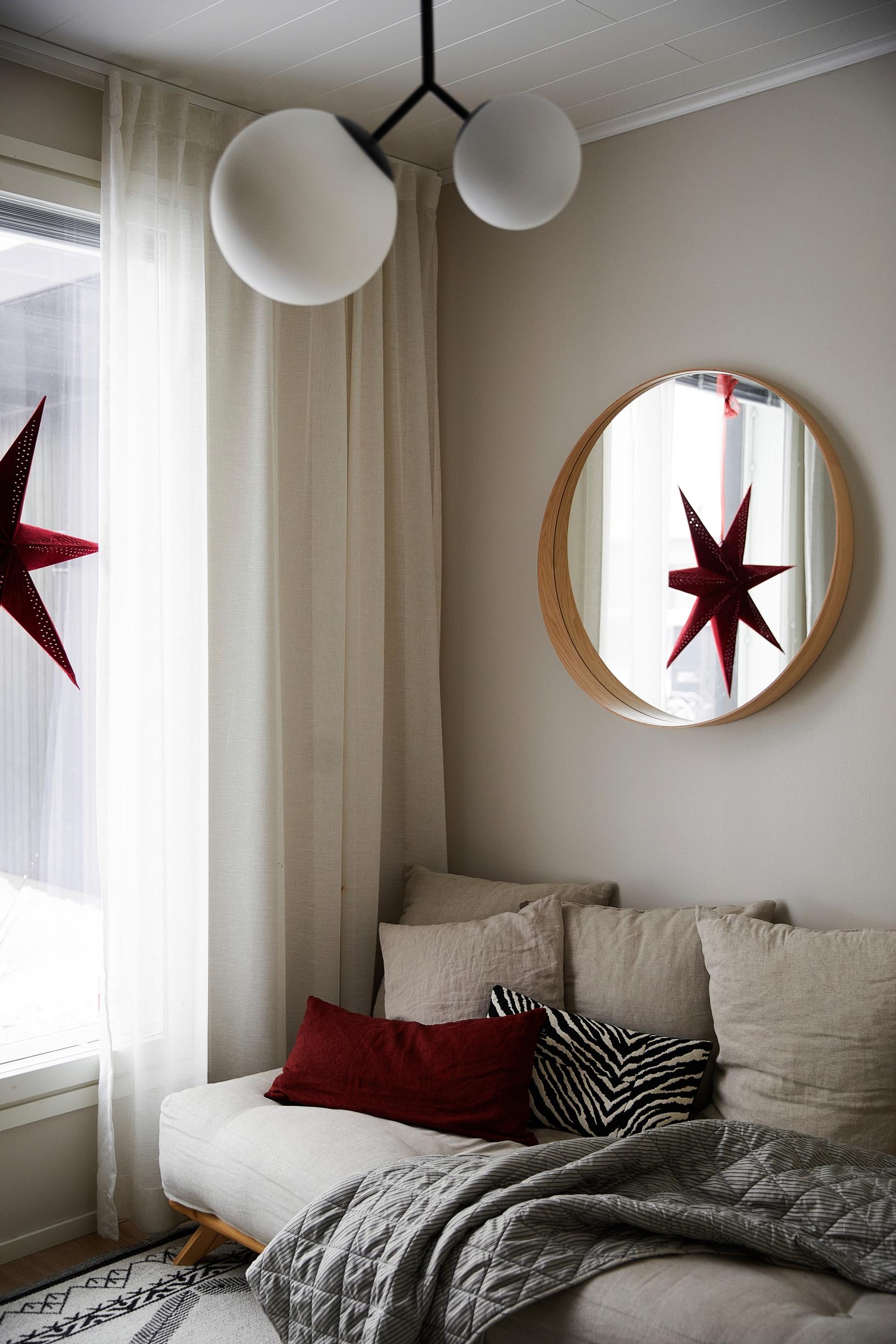 sofa, a red Christmas star in the window, and a mirror
