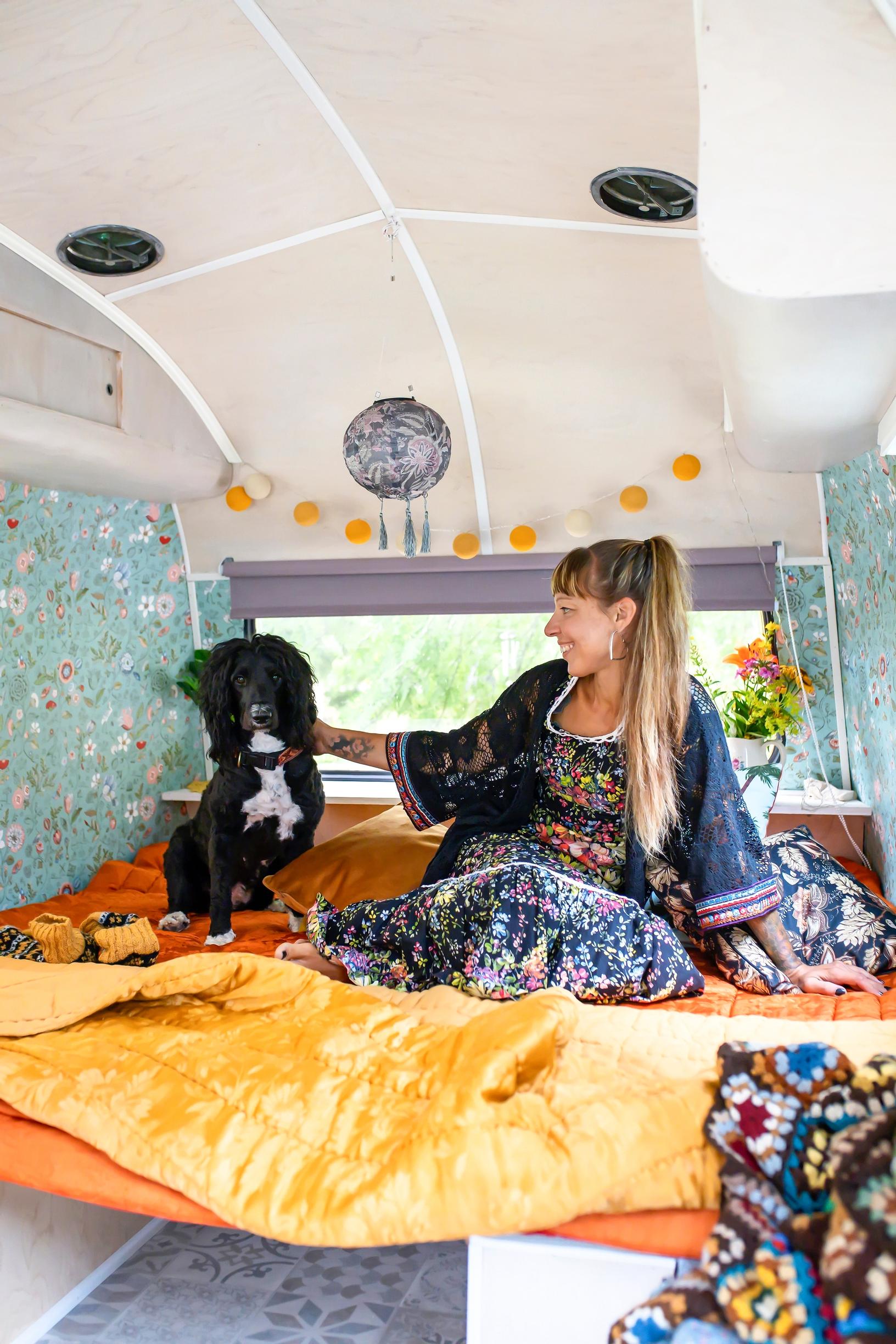 A woman and her dog in a bohemian caravan