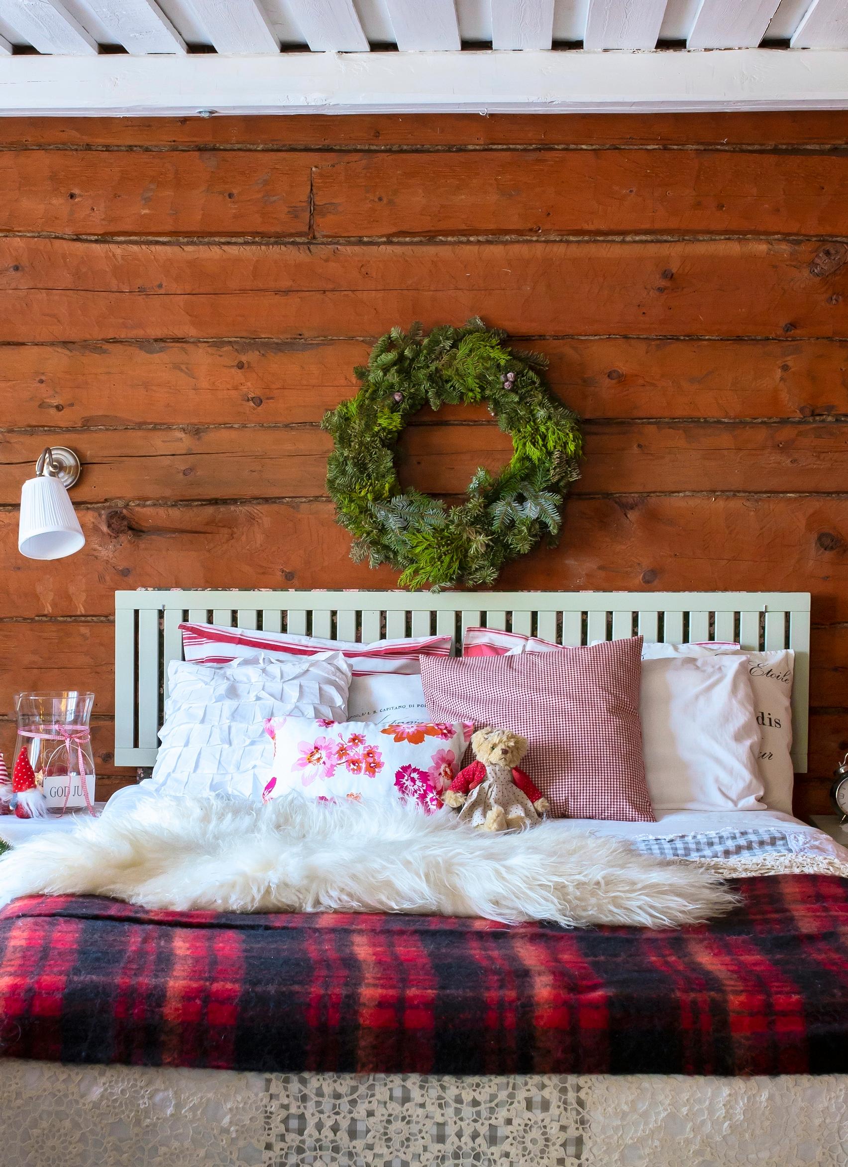 Evergreen wreath hanging above the bed