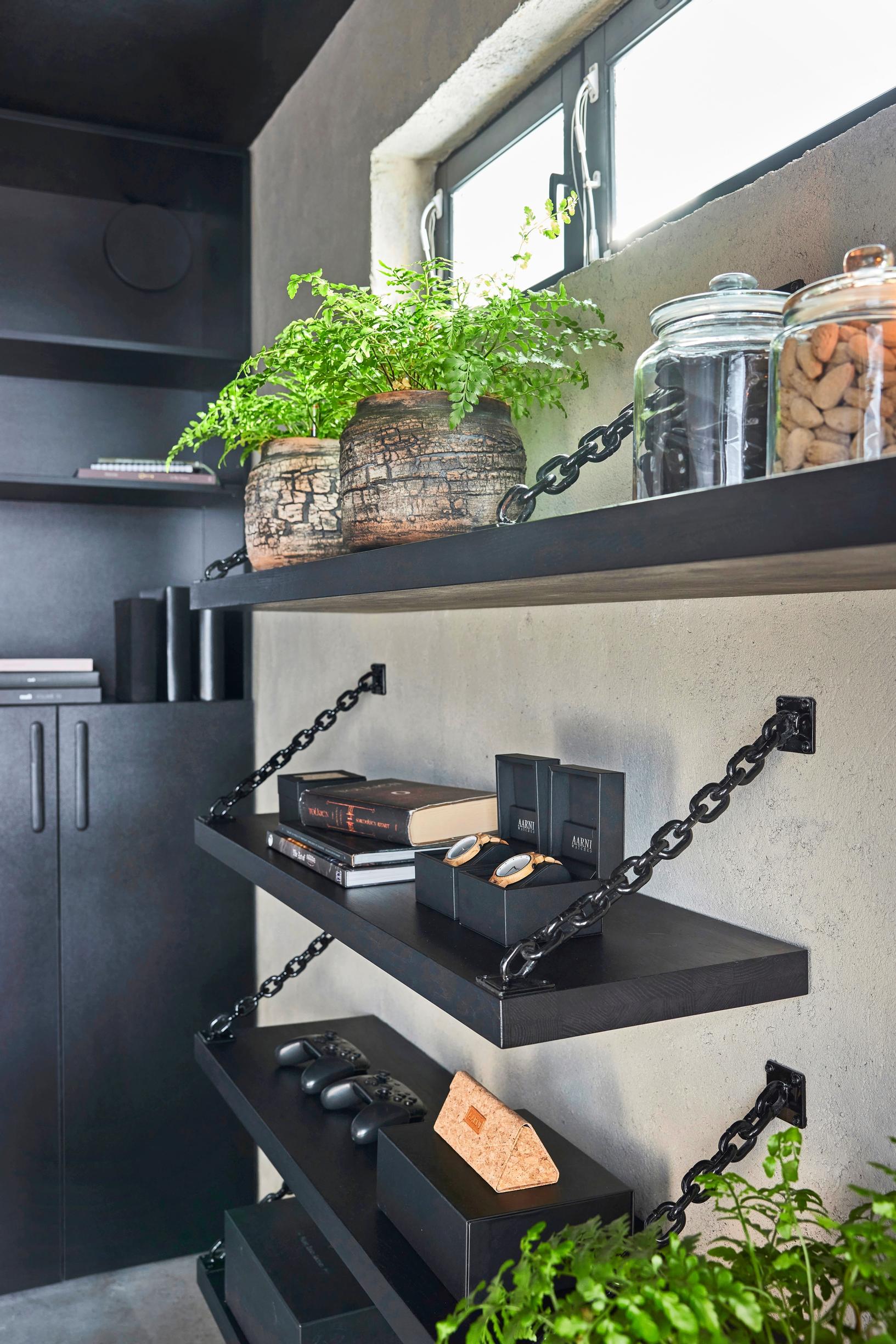 Black wall shelves supported by chains