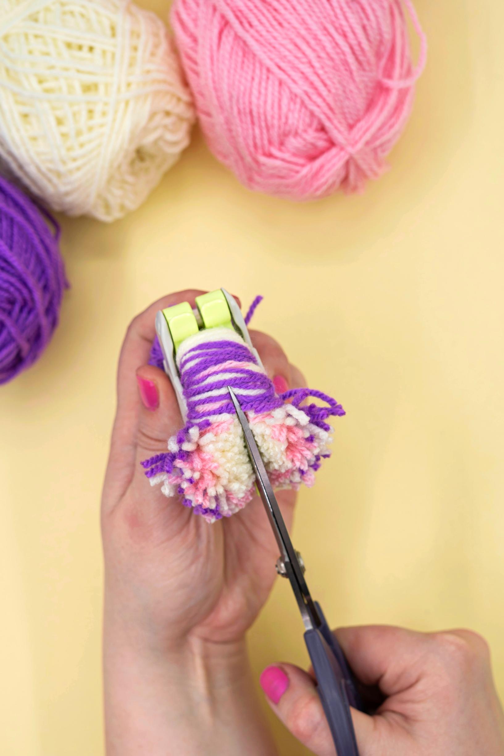 Cut the pompom yarn open along the outer edge of the maker.