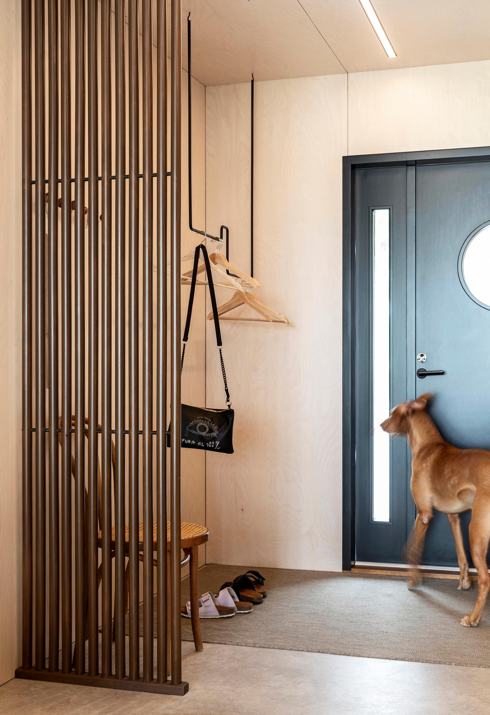 An entryway partition made from round slats